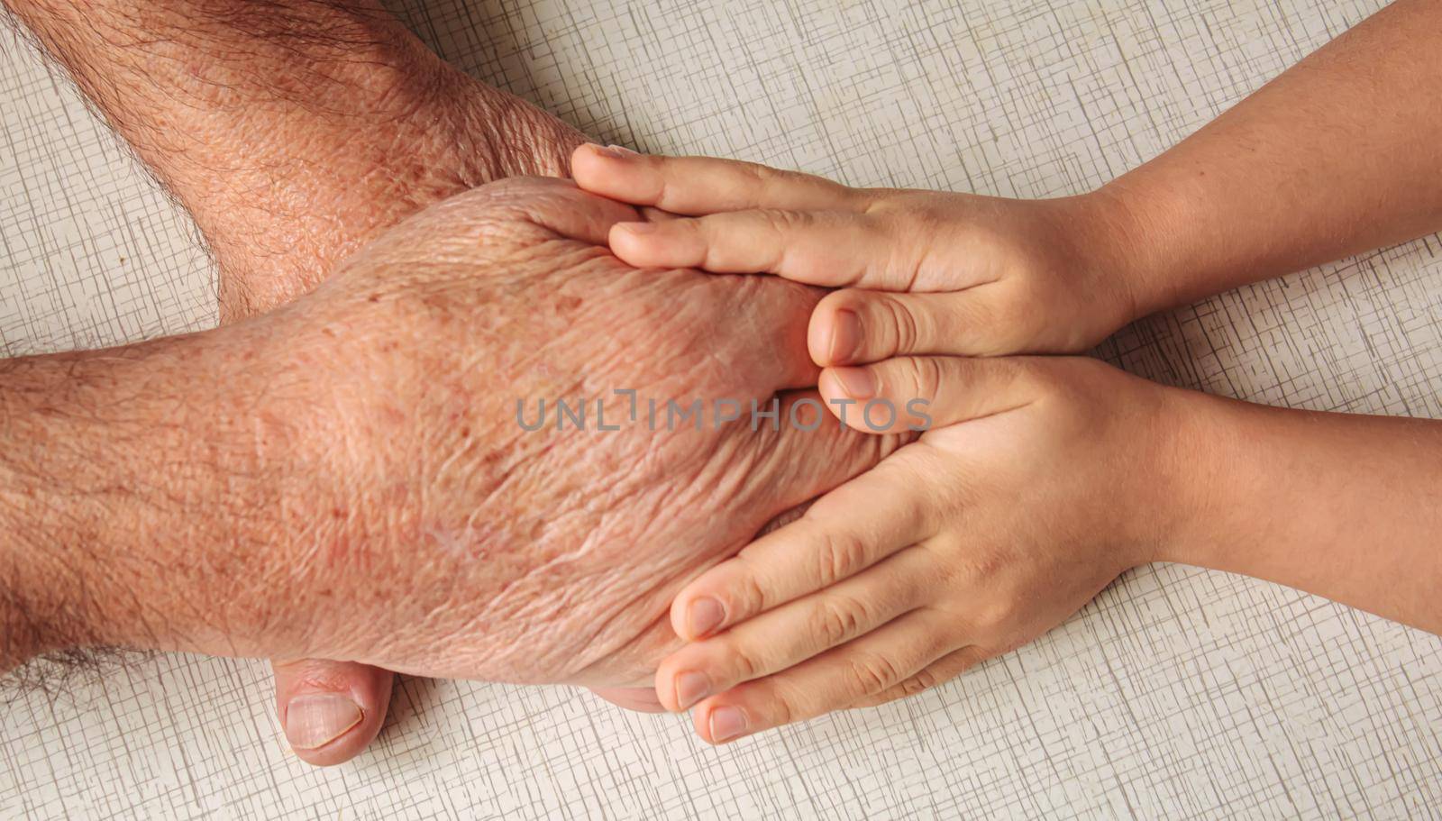 old man holding child's hands. selective focus people