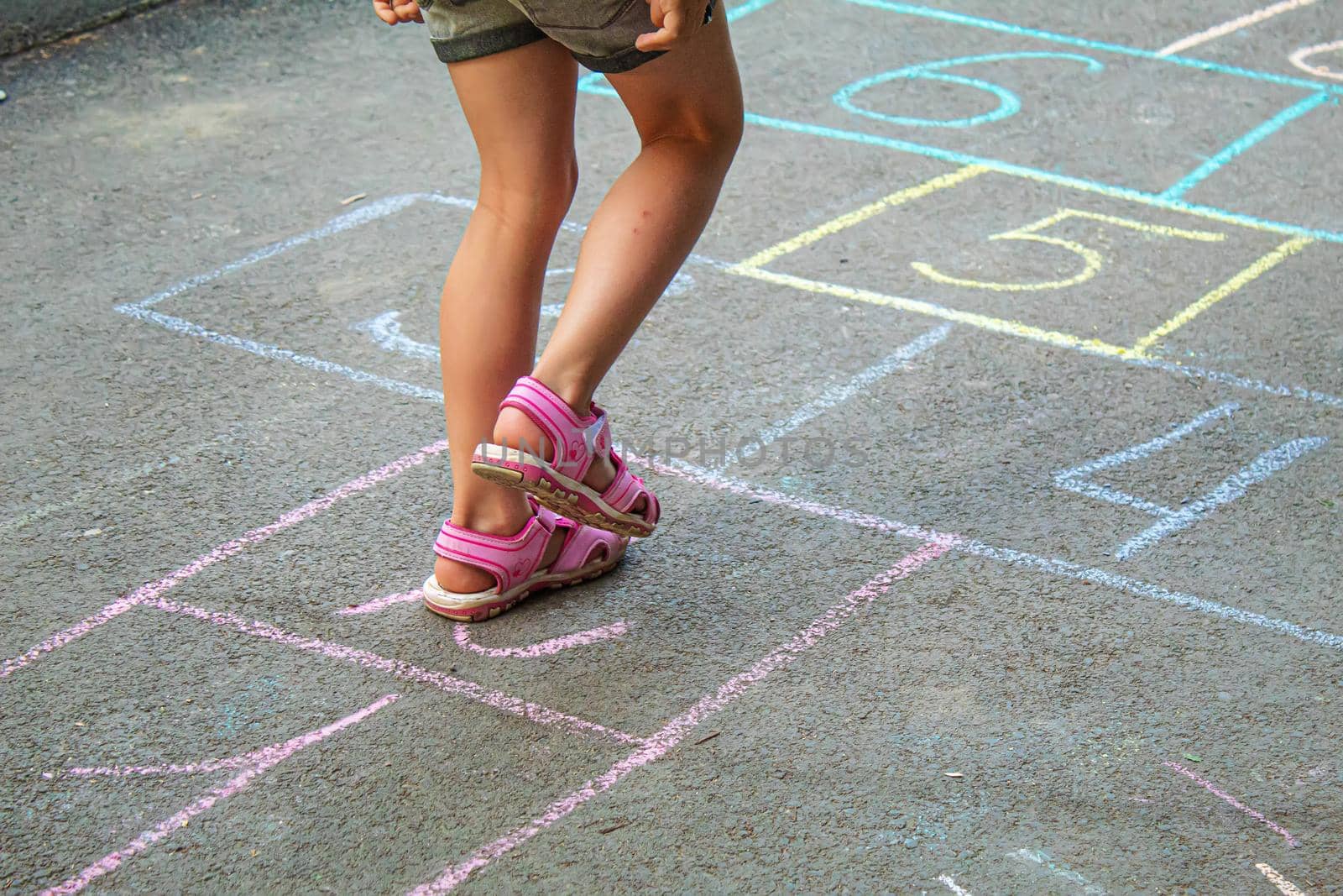 Child jumping classics on the pavement. Selective focus.child