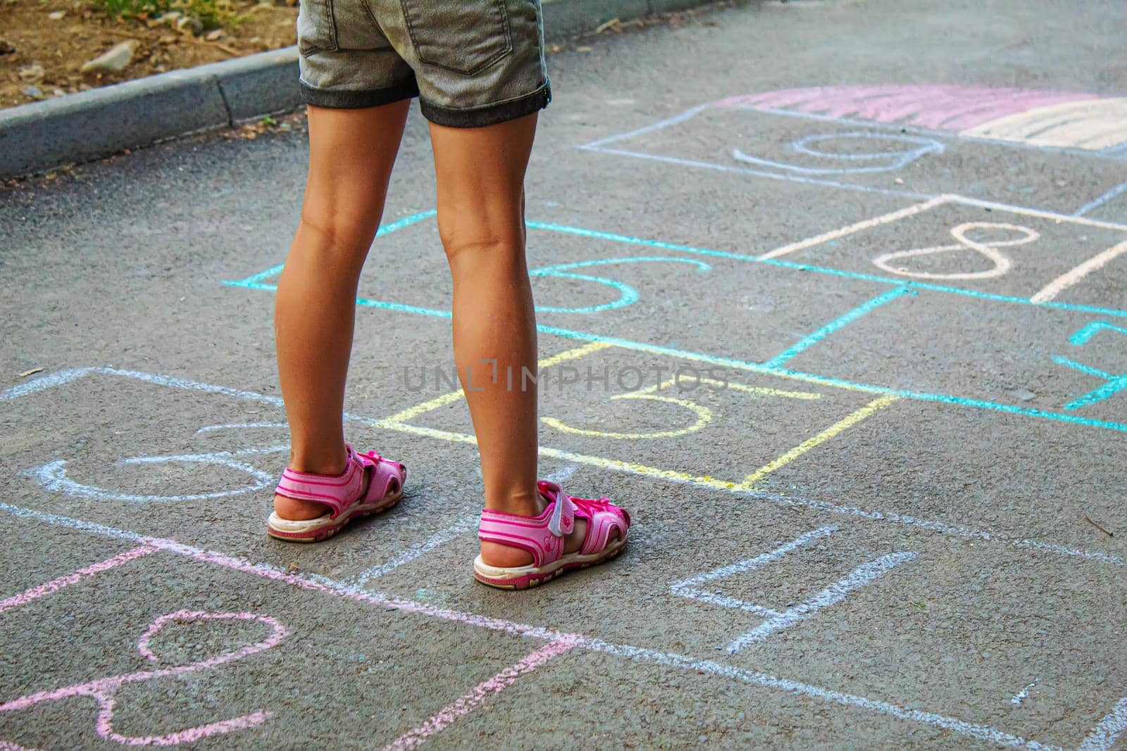 Child jumping classics on the pavement. Selective focus.child