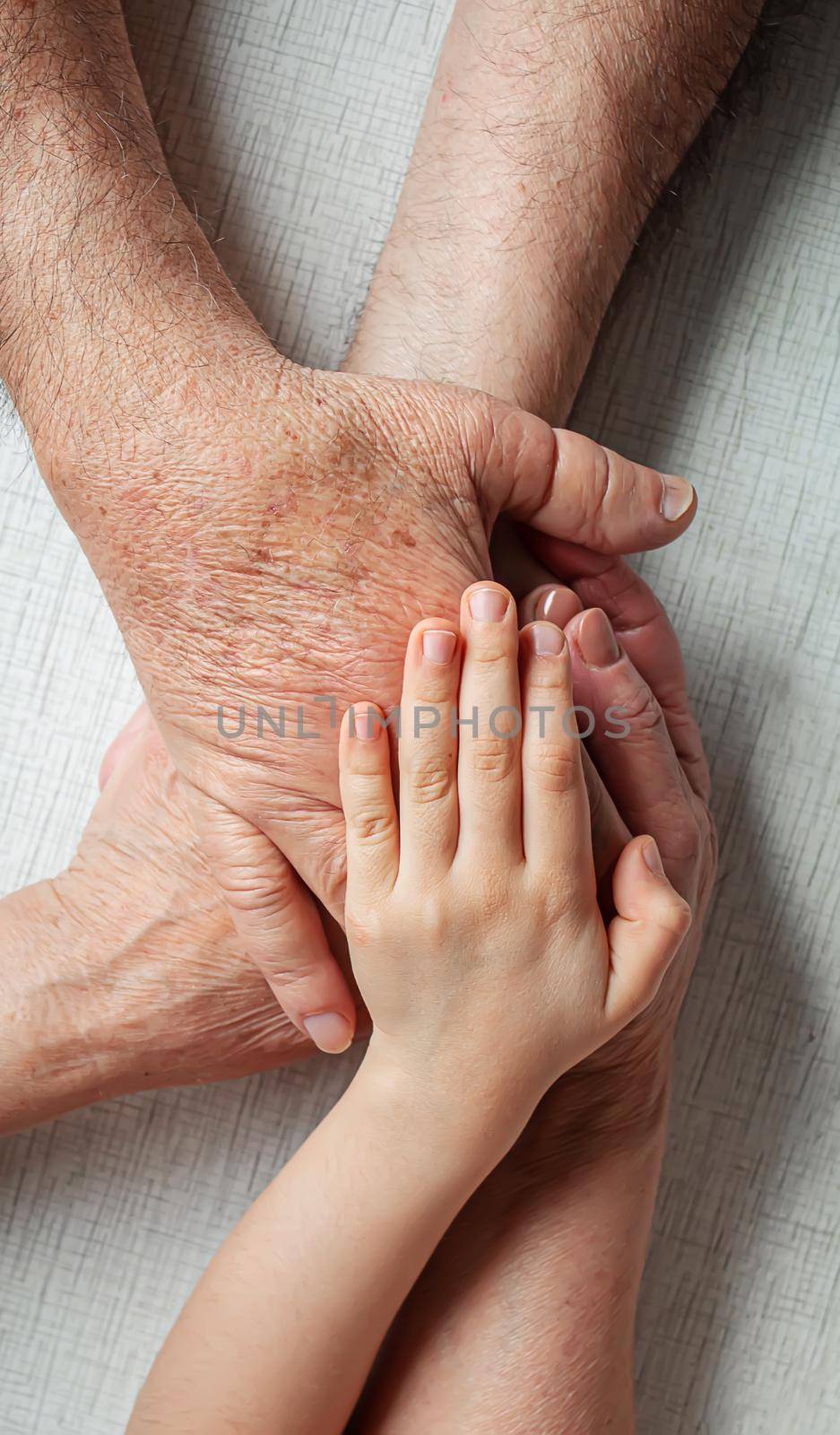 old man holding child's hands. selective focus people