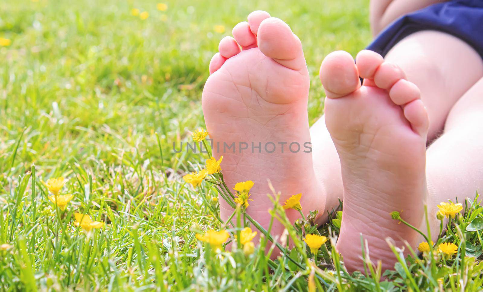 Child lying on green grass. Kid having fun outdoors in spring park. Selective focus. people