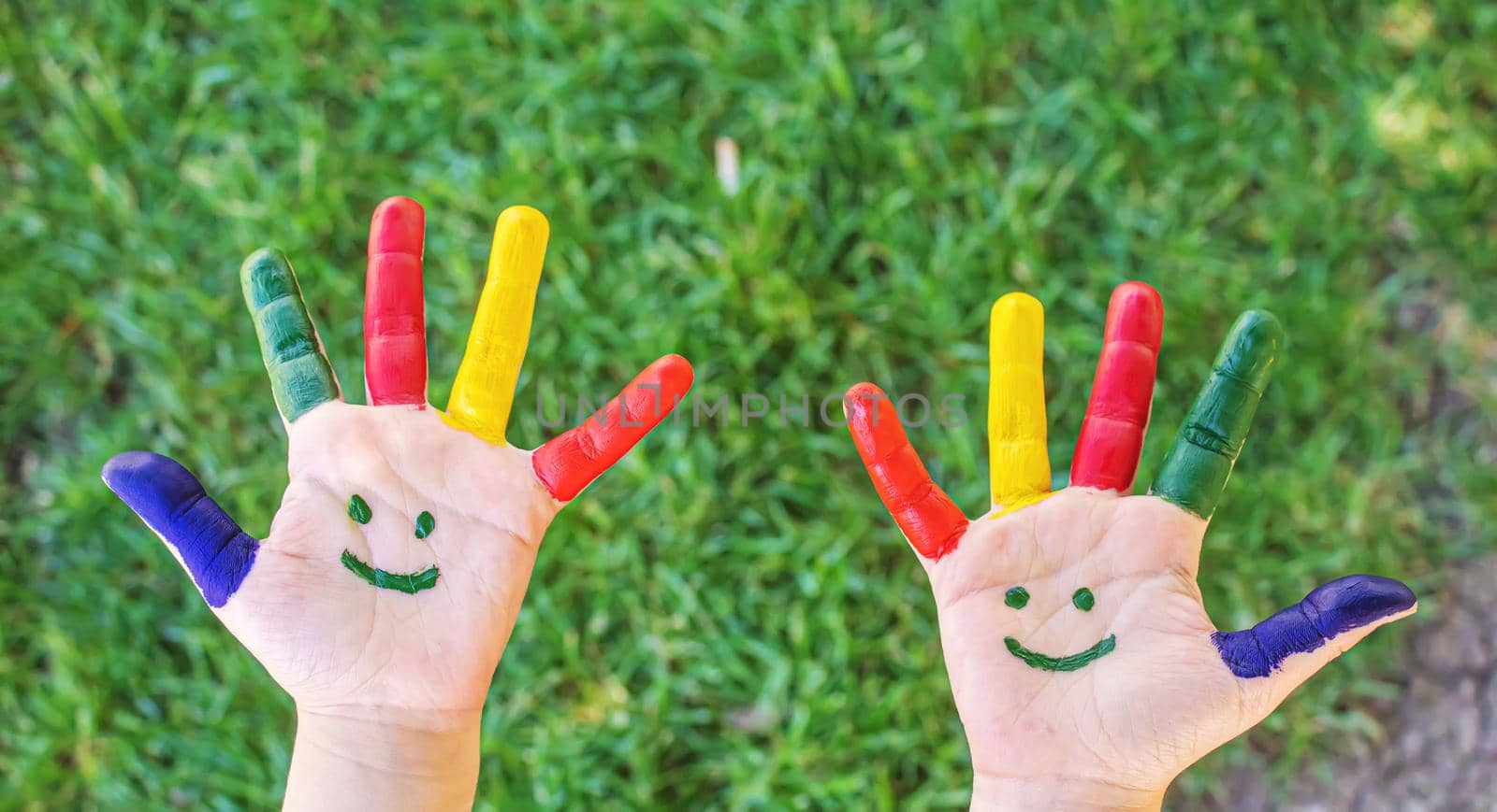 Children's hands in the colors of summer. Selective focus.nature