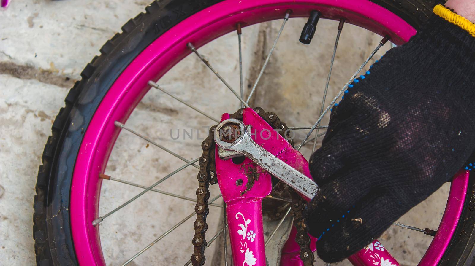 A father repairs his daughter's bike. selective focus