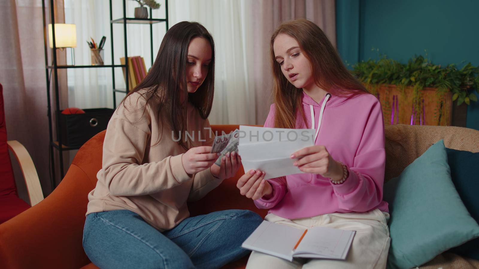 Girls siblings checking household payments, calculating bills, bank mortgage debt looking desperate about bankruptcy. Two female women couple family feels panic about financial problem at home in room