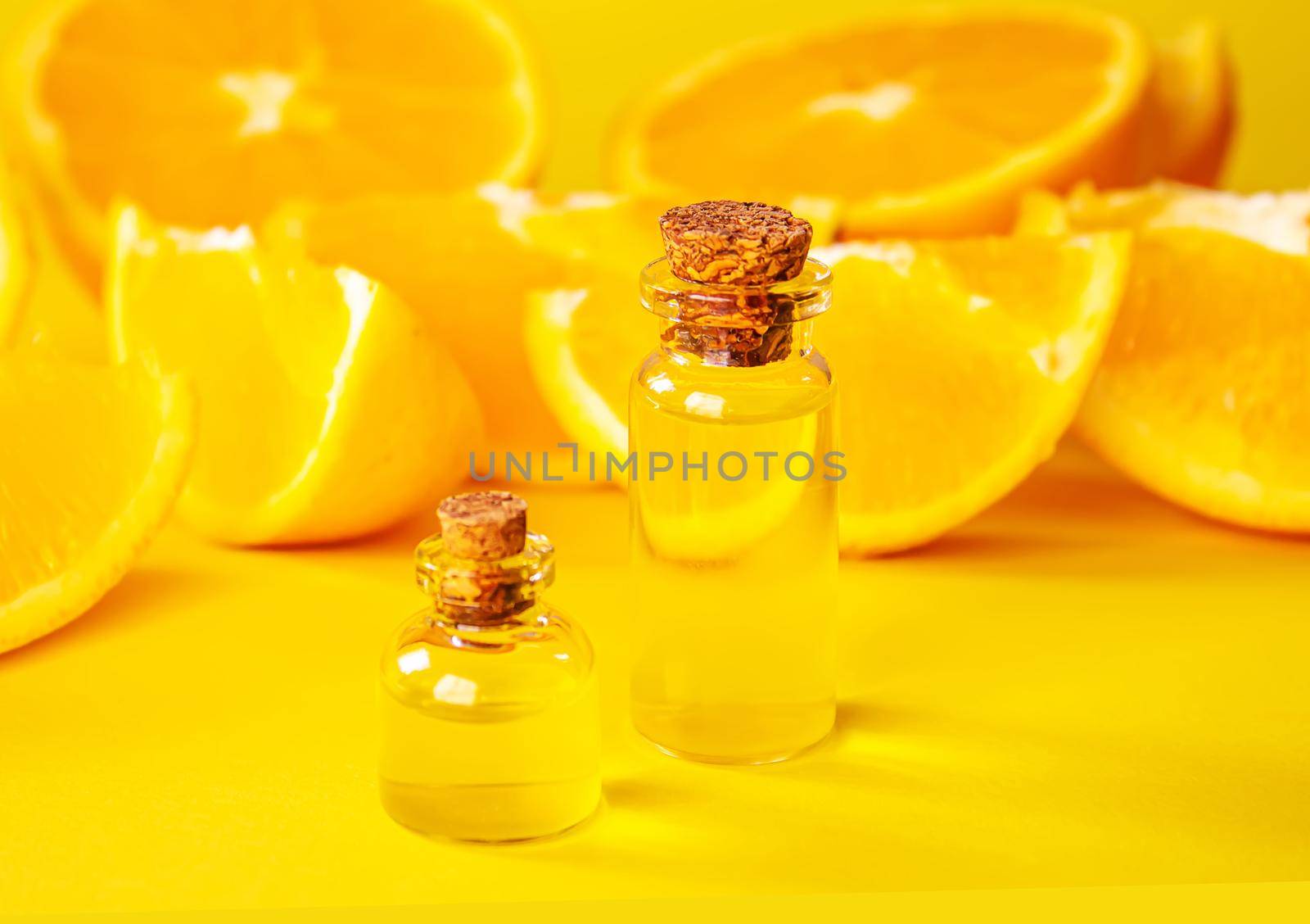 orange essential oil on a yellow background. Selective focus. by mila1784