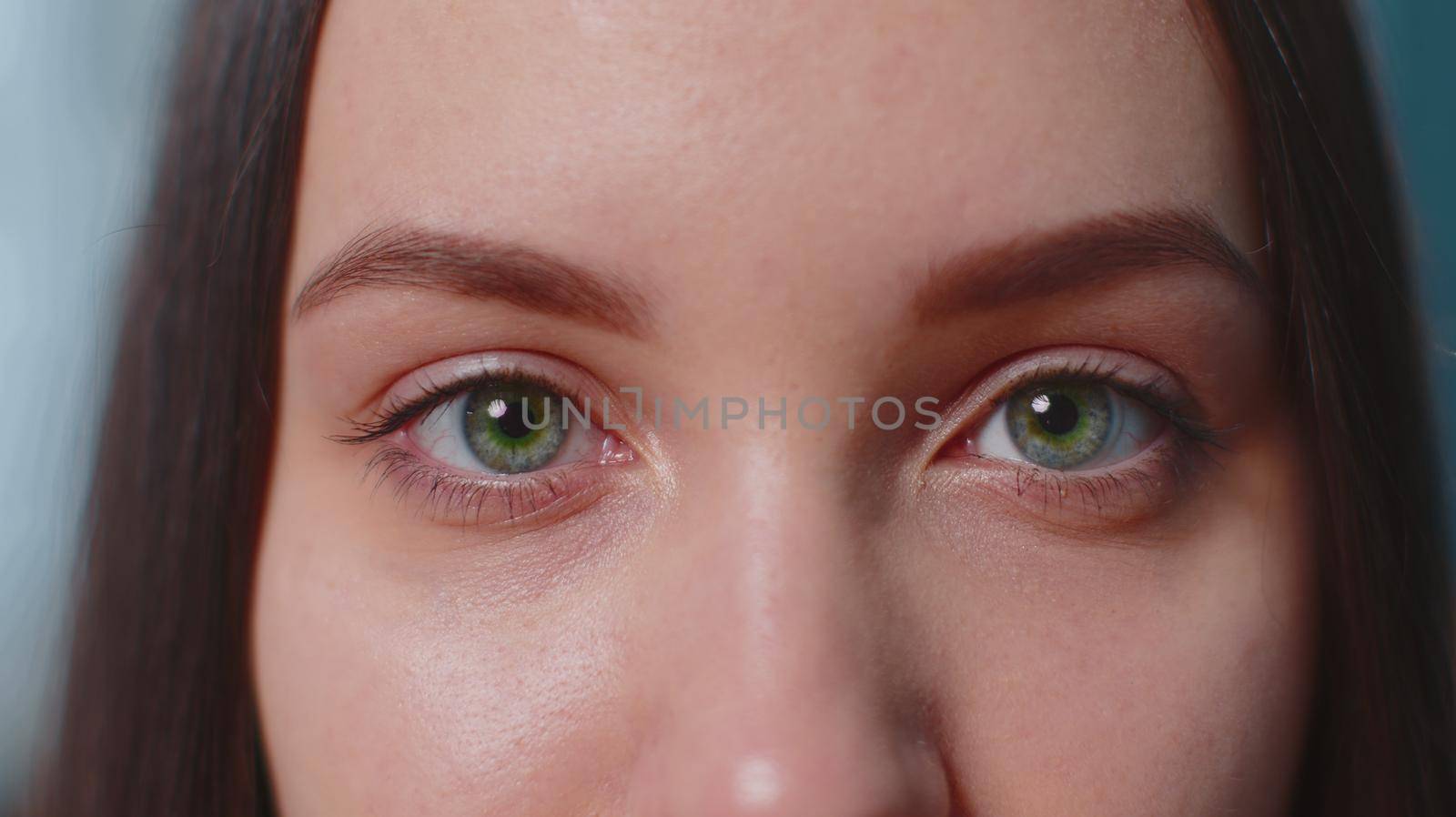 Close-up macro portrait of beauty young beautiful woman's eyes, smiling looking at camera. Gray brown eyes of woman face, girl female model. Lady opening blinking her eyes. Slow motion 4k footage