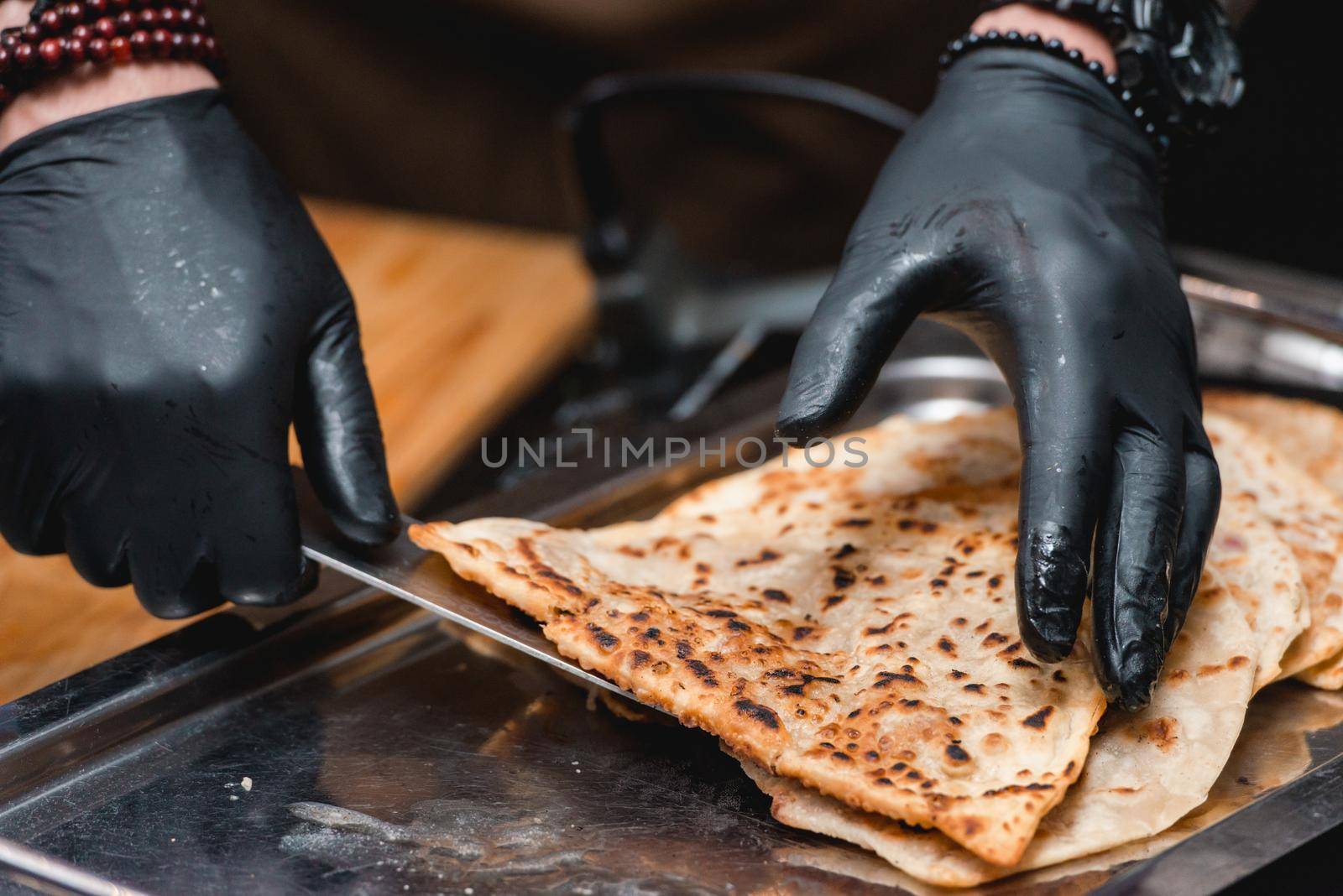 Chief serving cheburek - traditional balkan meat pastry pie with herbs on a white plate by Ashtray25