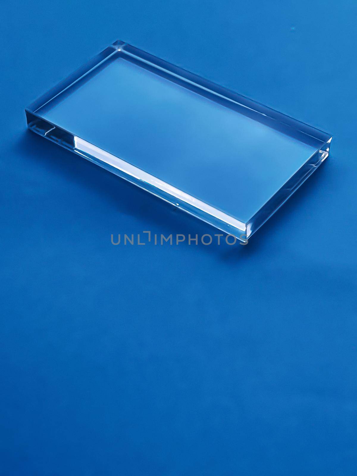 Transparent glass device on blue background, future technology and abstract screen mockup design concept