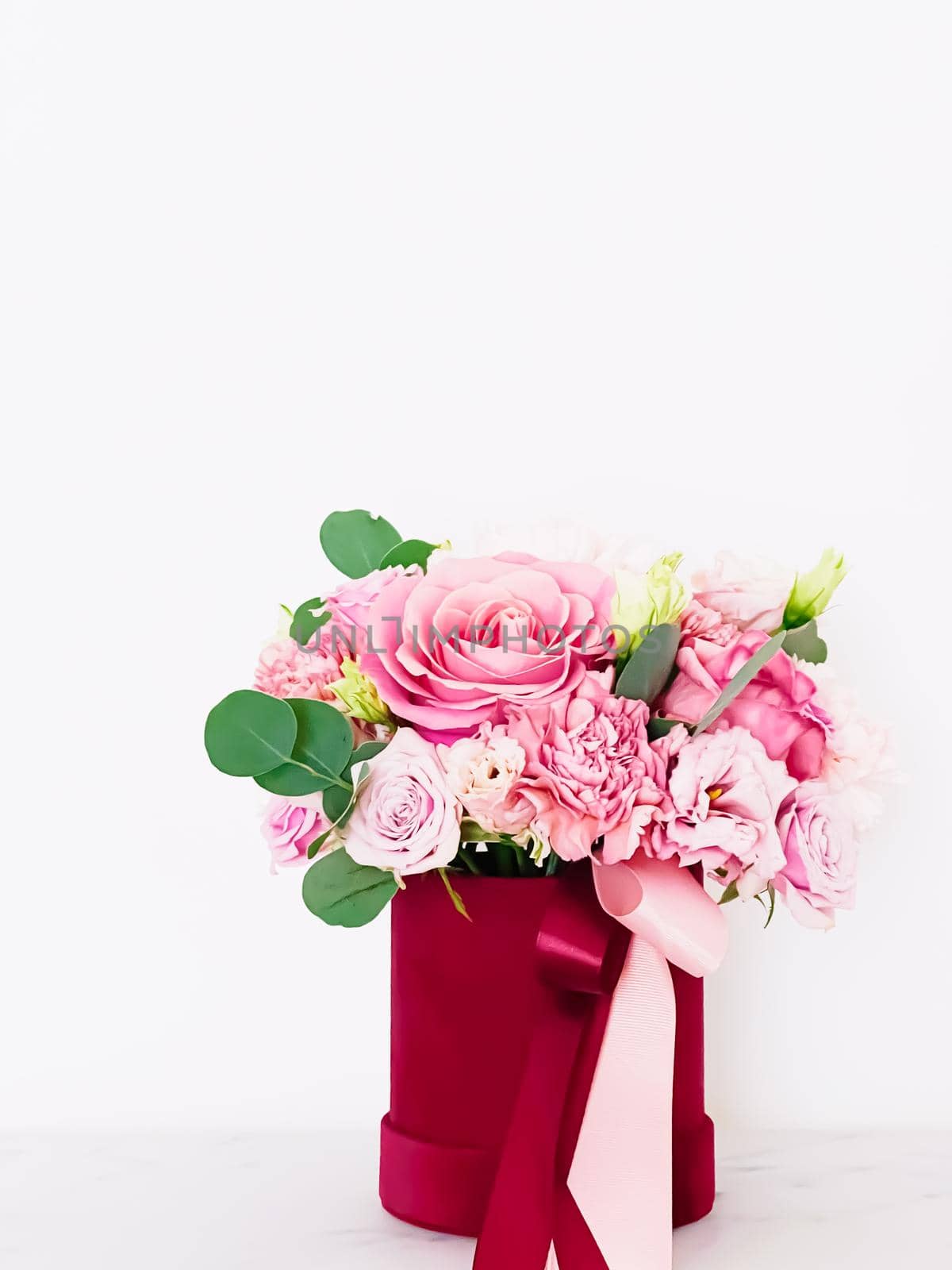 Beautiful bouquet of blooming flowers in red flower box on white background, holiday gift, luxury floral design concept