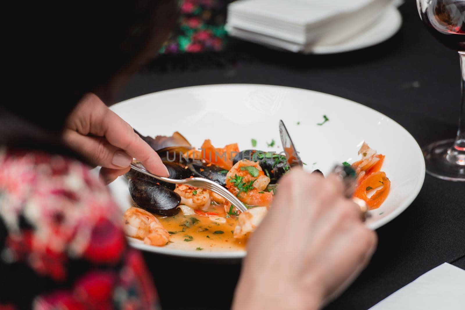 Woman eats a seafood dish in a restaurant.