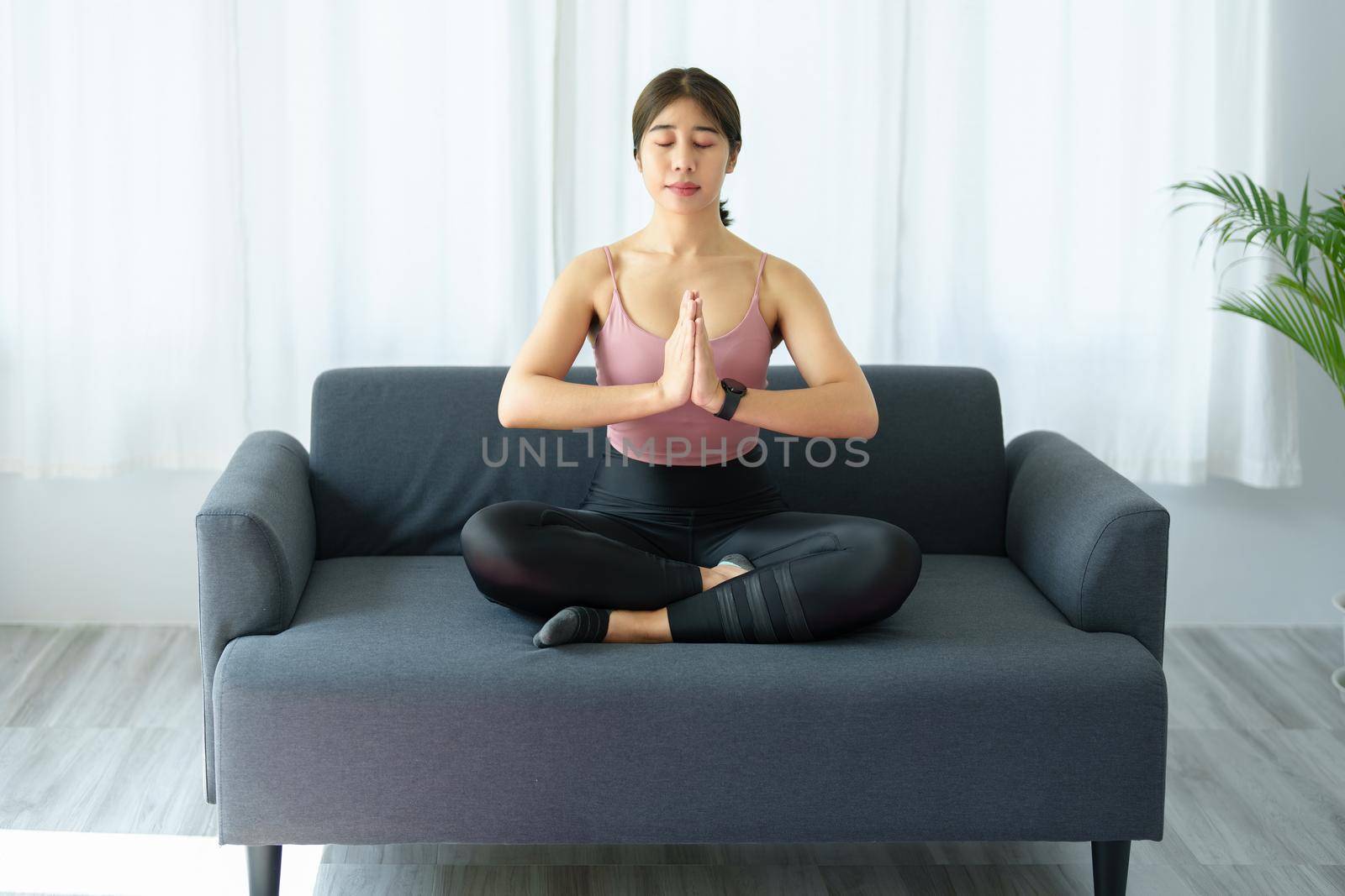 stress relief, muscle relaxation, breathing exercises, exercise, meditation, portrait of Young Asian woman relaxing her body from office work by practicing yoga by watching online tutorials. by Manastrong