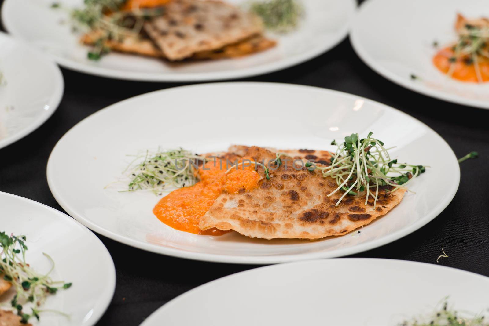 Cheburek traditional balkan meat pastry pie with herbs on a white plate. Served with sauce and micro green by Ashtray25