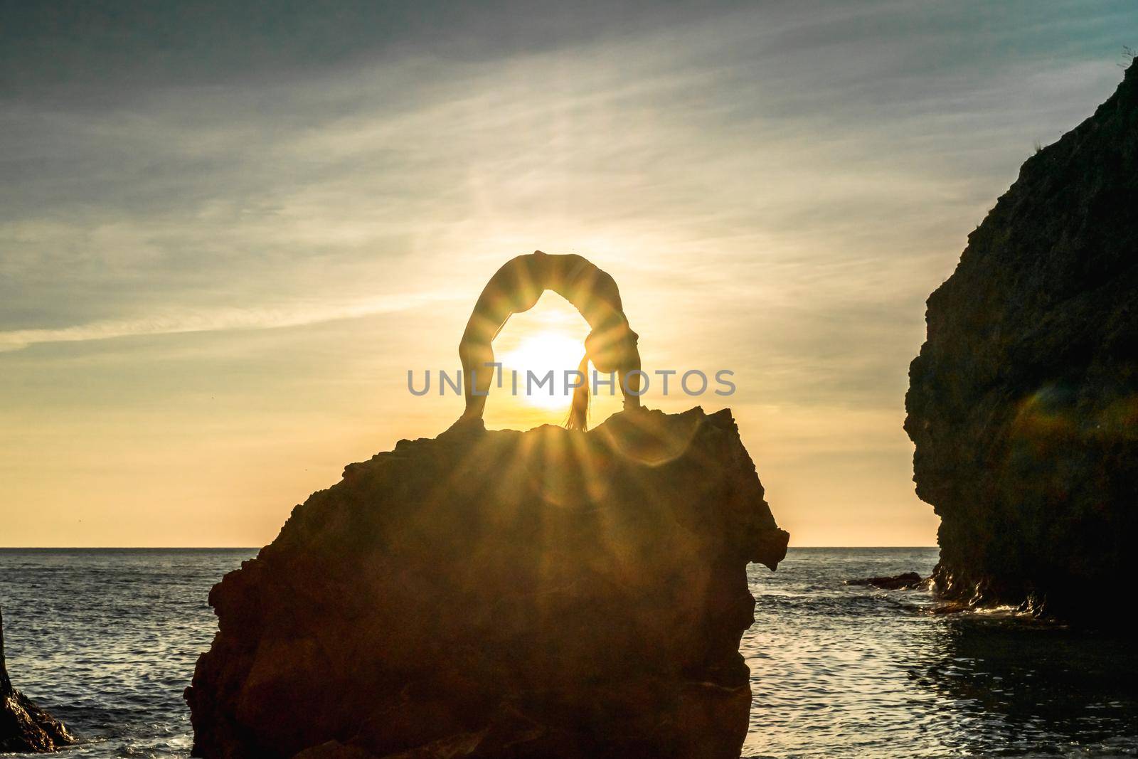 Girl gymnast is training on the beach by the sea sunset. Does twine. Photo series