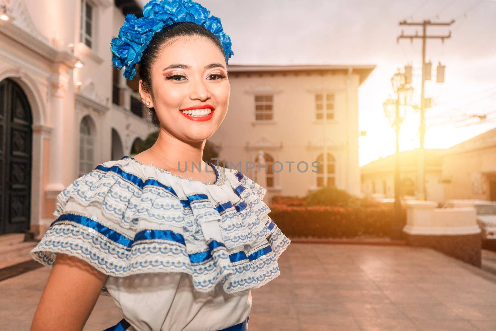 Traditional dancer from Nicaragua. Latin girl smiling with the traditional dress of Mexico, Central and South America, looking at the camera at sunset.