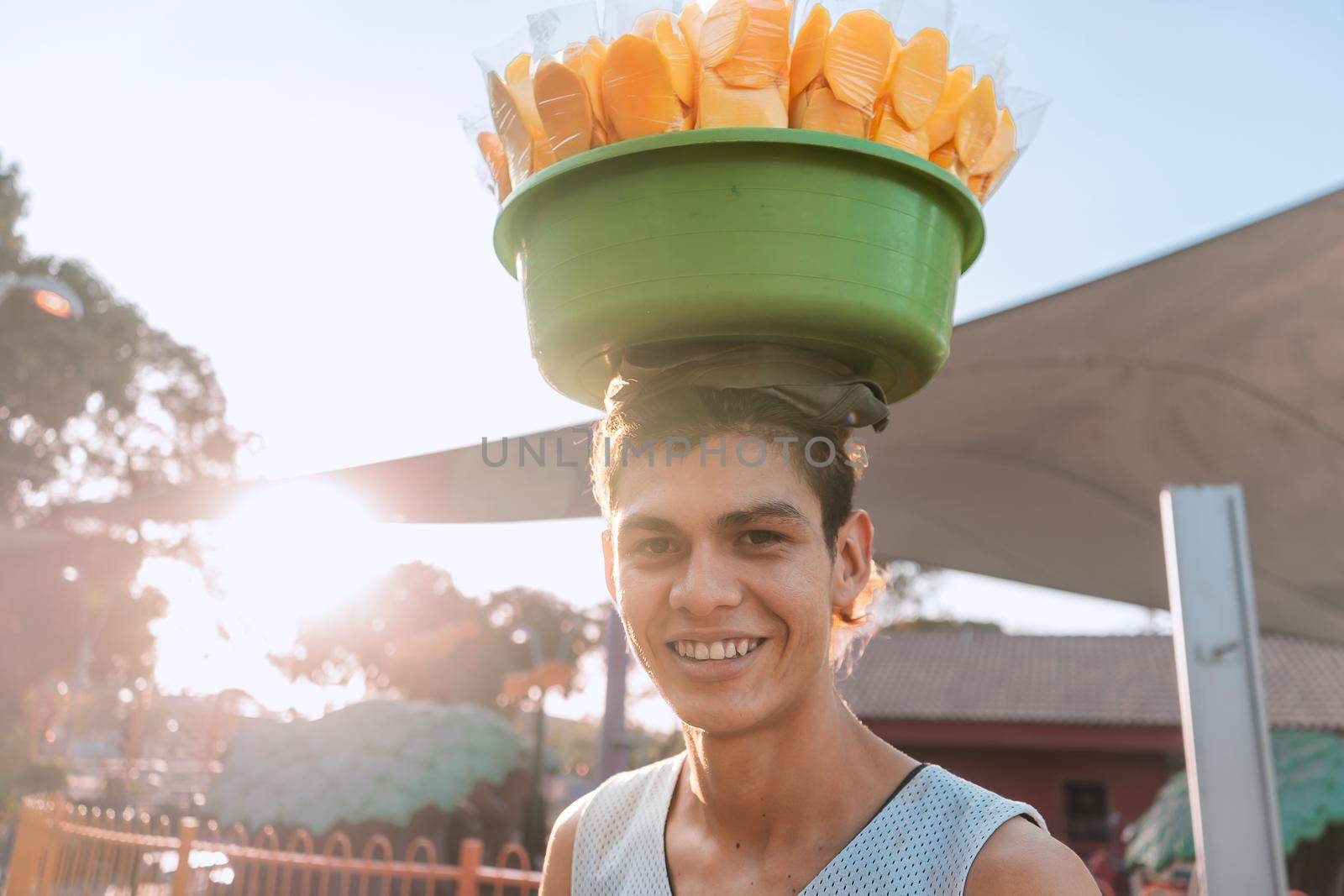 Portrait of a young white latin man street vendor selling mangoes at sunset in Managua, Nicaragua by cfalvarez