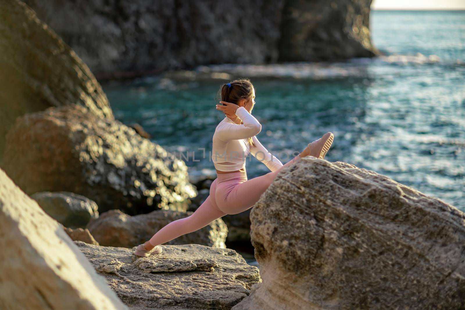 Girl gymnast is training on the beach by the sea. Does twine. Photo series.