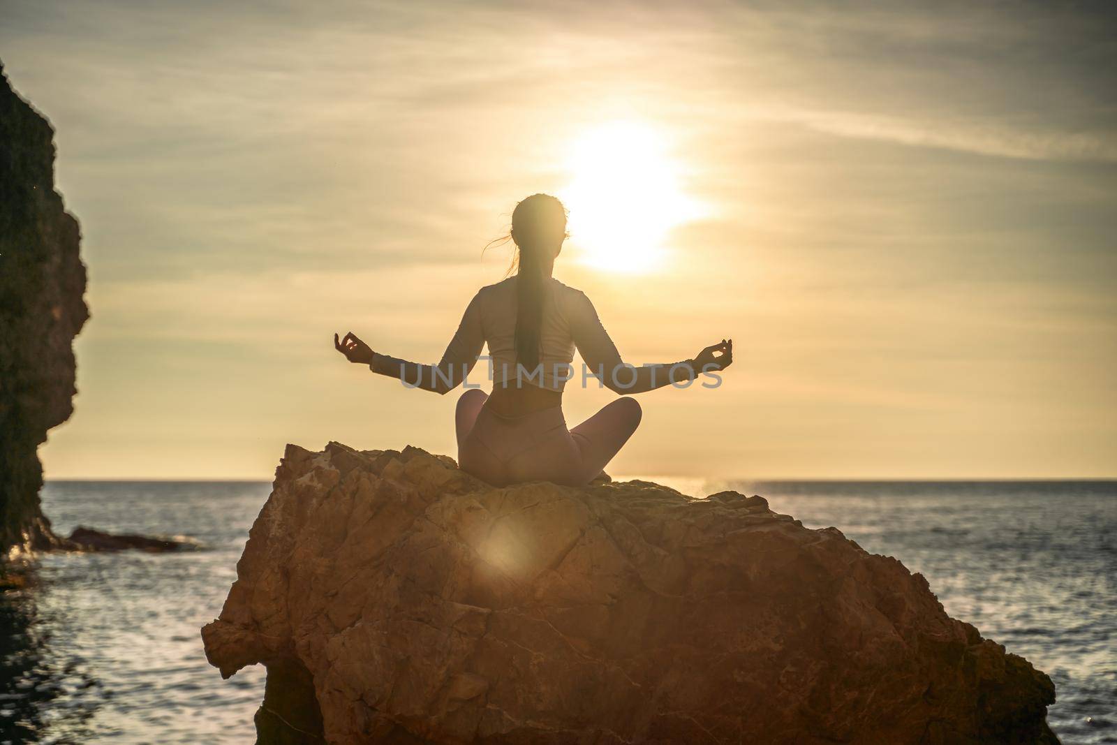 Young woman practicing yoga outdoors. Harmony and meditation concept. Healthy lifestyle by Matiunina