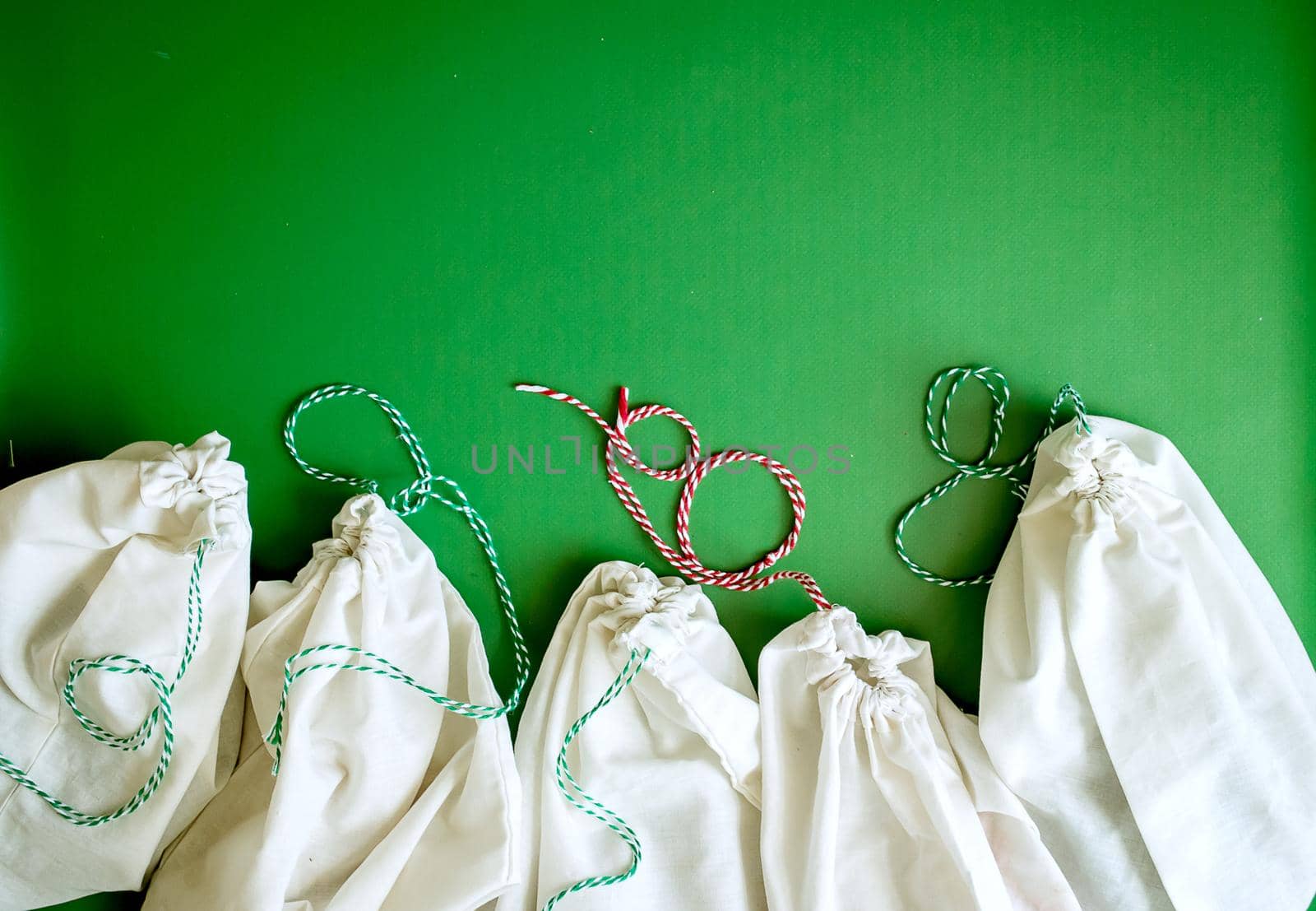zero waste products in reusable cotton bags on a green background. High quality photo