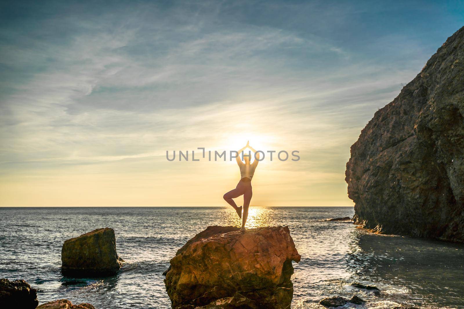 Girl gymnast is training on the beach by the sea sunset. Does twine. Photo series. by Matiunina