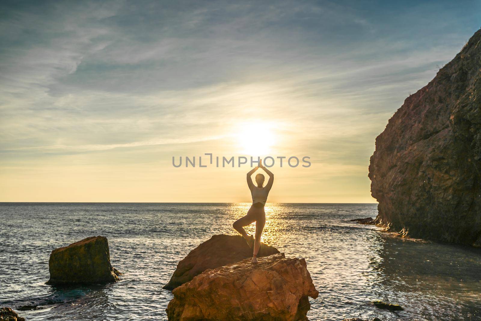 Girl gymnast is training on the beach by the sea sunset. Does twine. Photo series