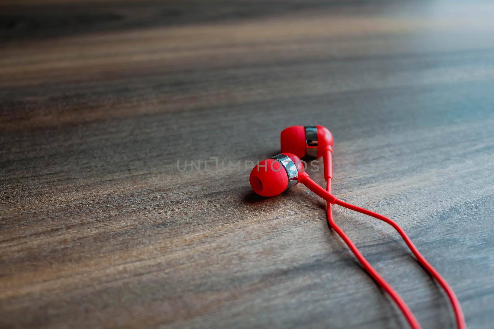 Bright Red earbuds headphones on wooden background