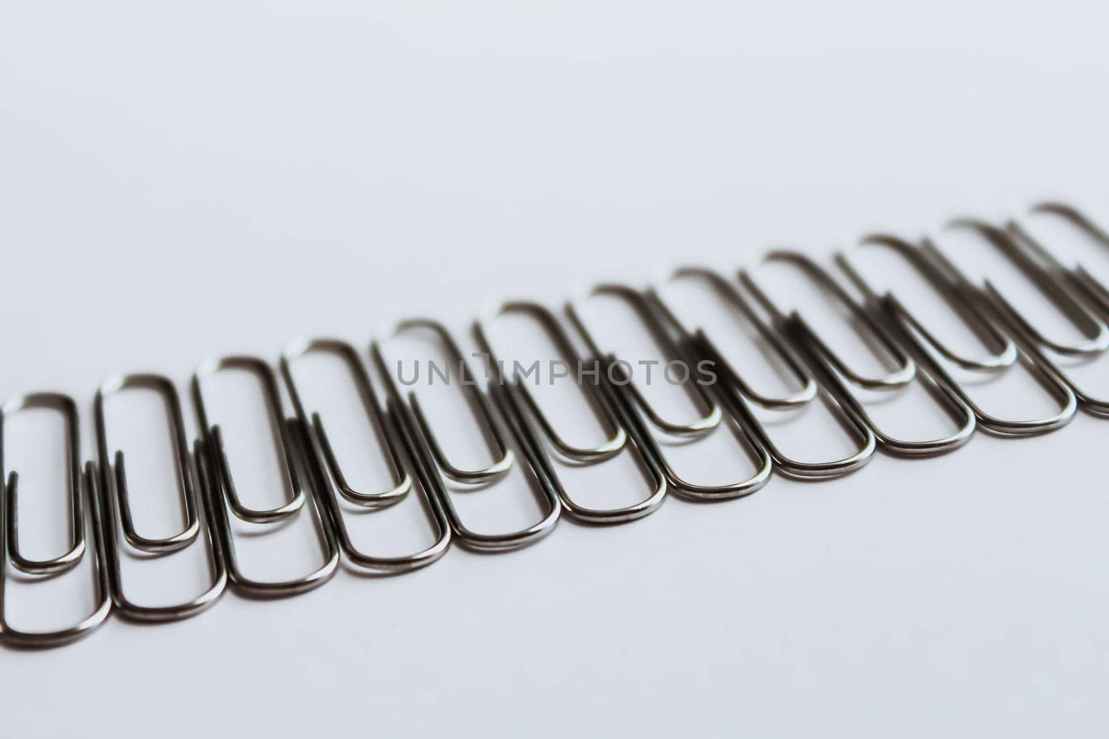 Metal paper clips on white background. Side view. by JuliaDorian