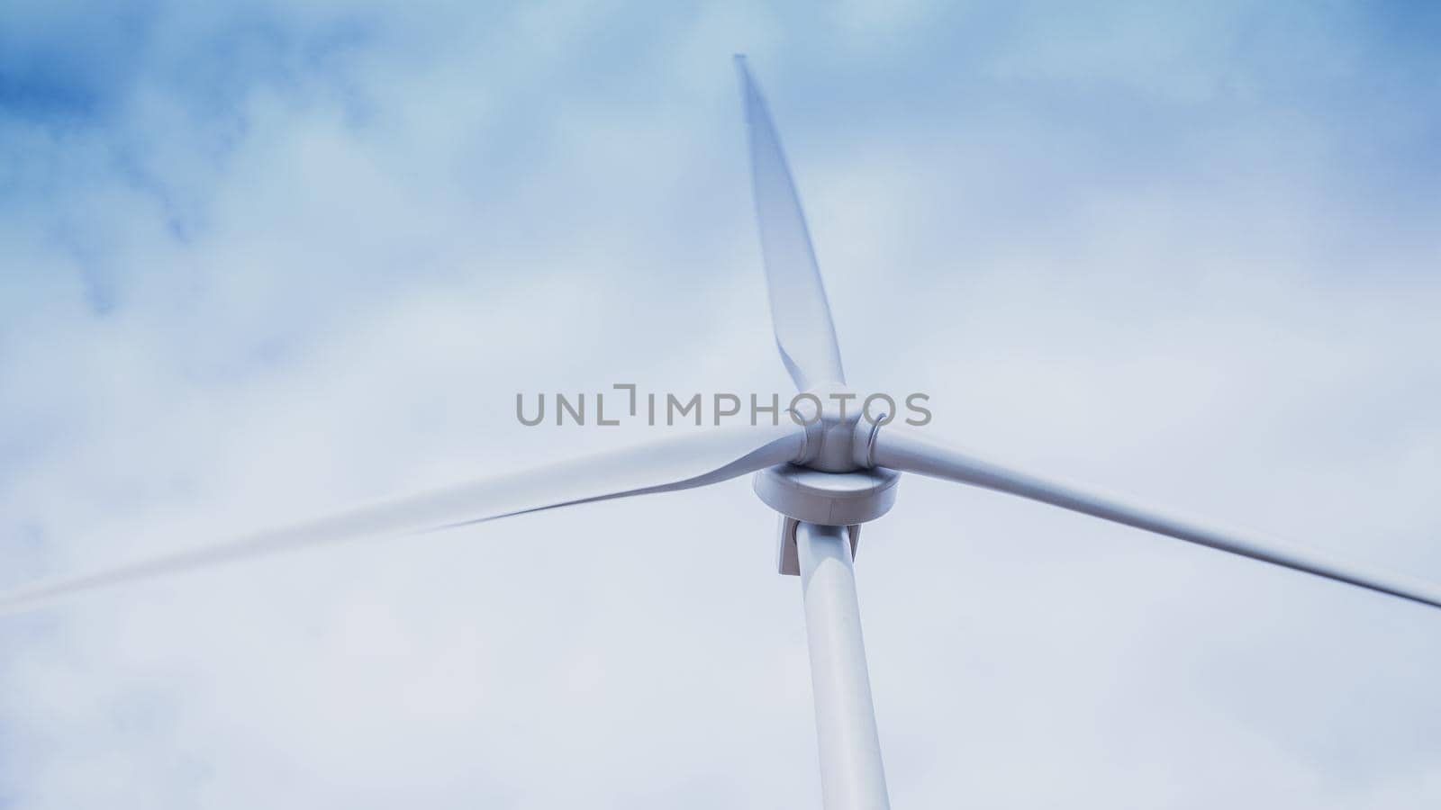 Blue sky, white clouds and wind turbine. Wind generator for electricity, alternative energy source. Windmill for electric power production. Ecology concept.