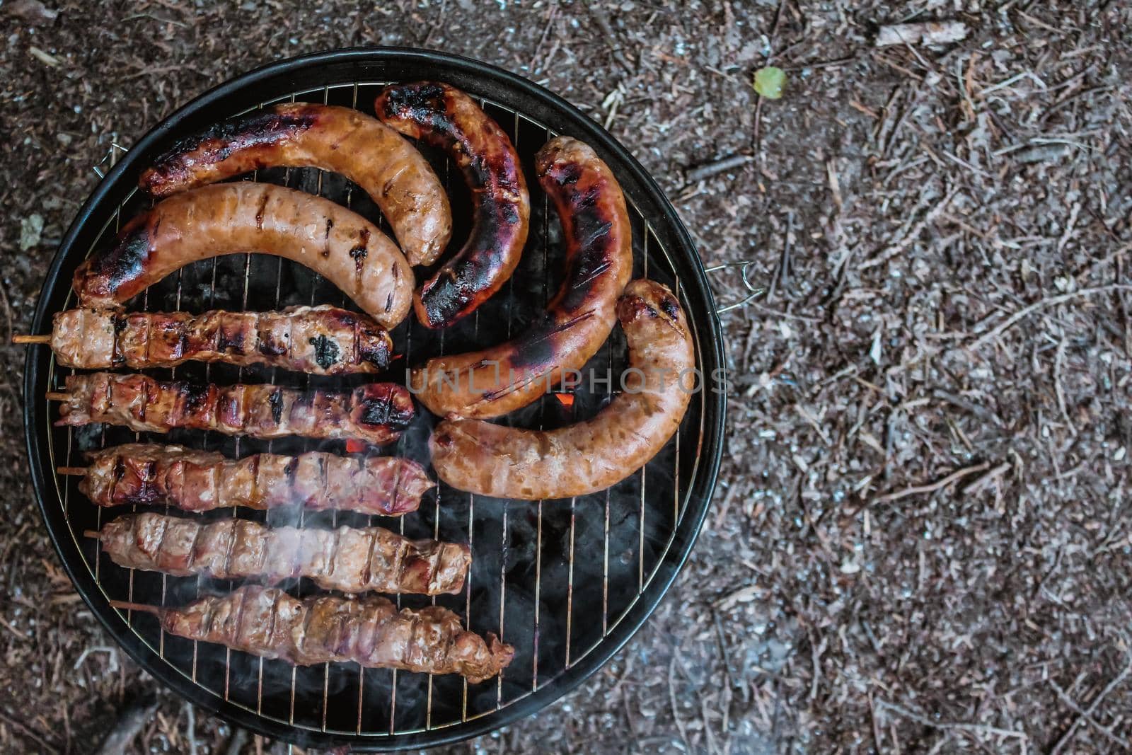 bbq meat and sausages on charcoal grill top view by JuliaDorian