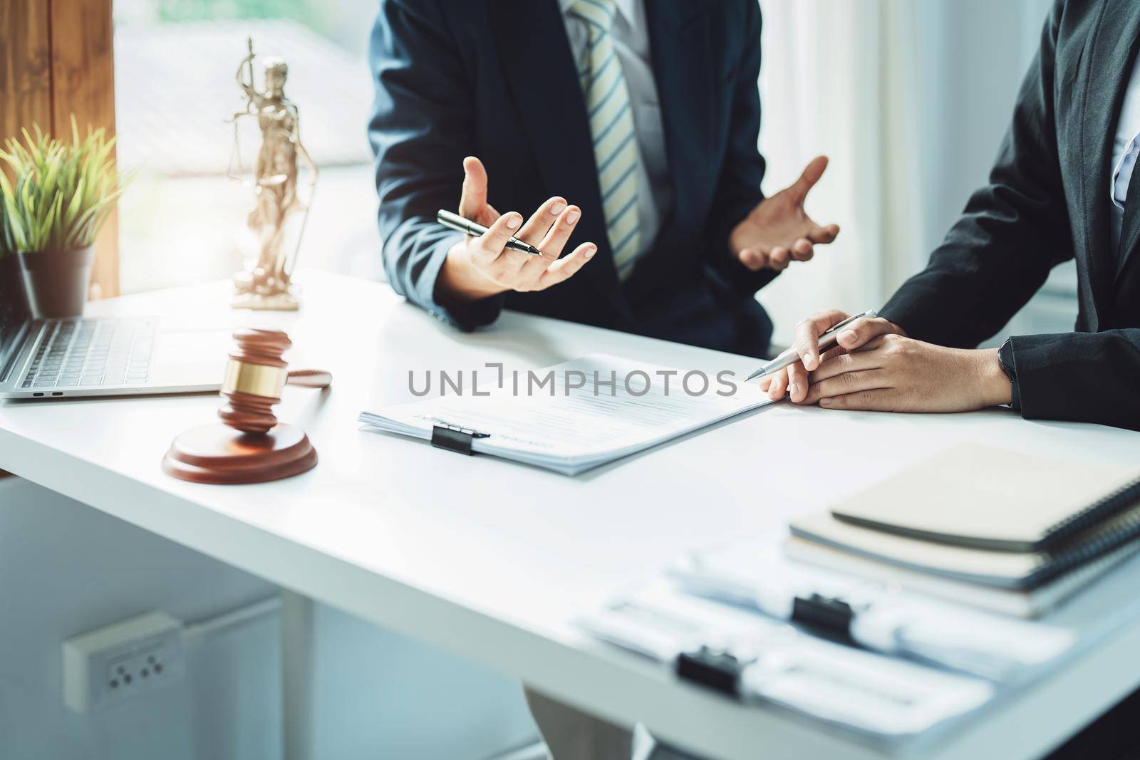 Law, Consultation, Agreement, Contract, Attorney or Lawyer holding a pen is consulting with a client to explain the pattern of answering questions before going to court to decide a lawsuit. by Manastrong