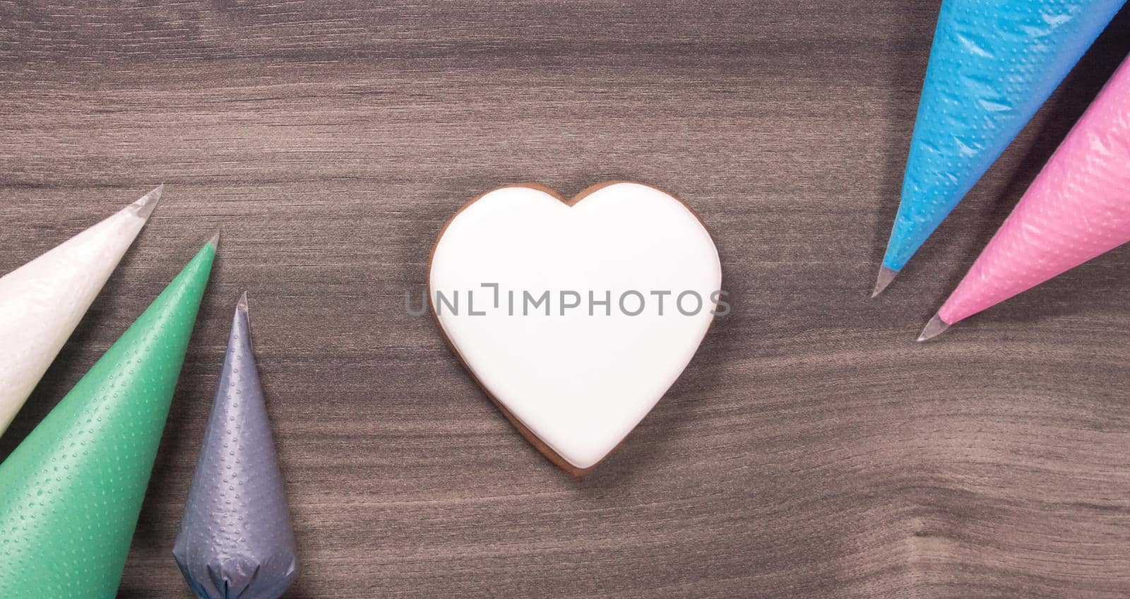 Big white heart shape cookie with icing cones for Mothers day, Womans day or Valentines Day on wooden background. Copy space.