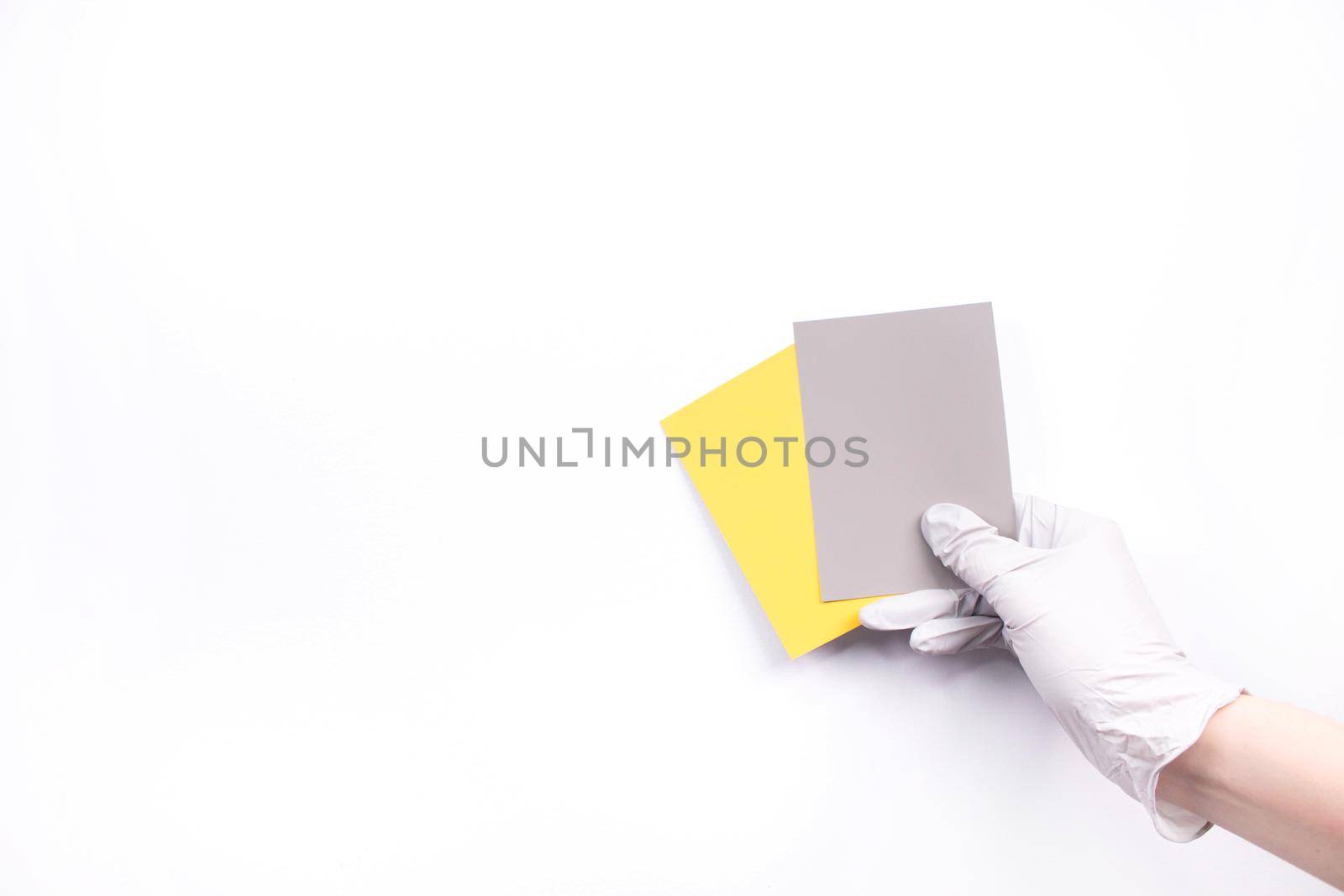 Women's hands hold swatches of the trendy colors - illuminating yellow and ultimate grey. Selection of year 2021 colors for design of clothes, interiors, websites and publications. by JuliaDorian