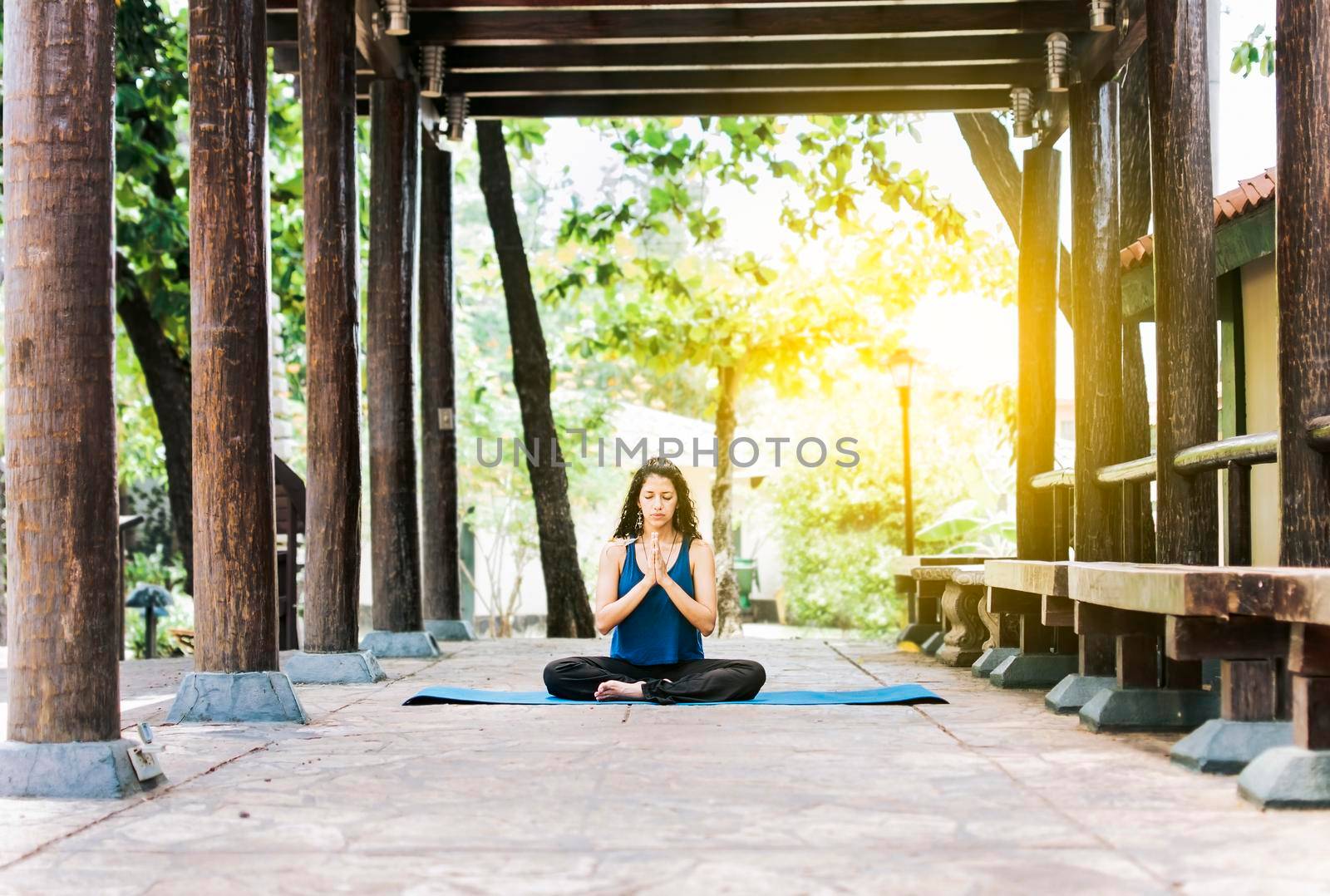 A girl sitting doing meditation yoga outdoors, Woman doing yoga outdoors, a young woman doing yoga with closed eyes.