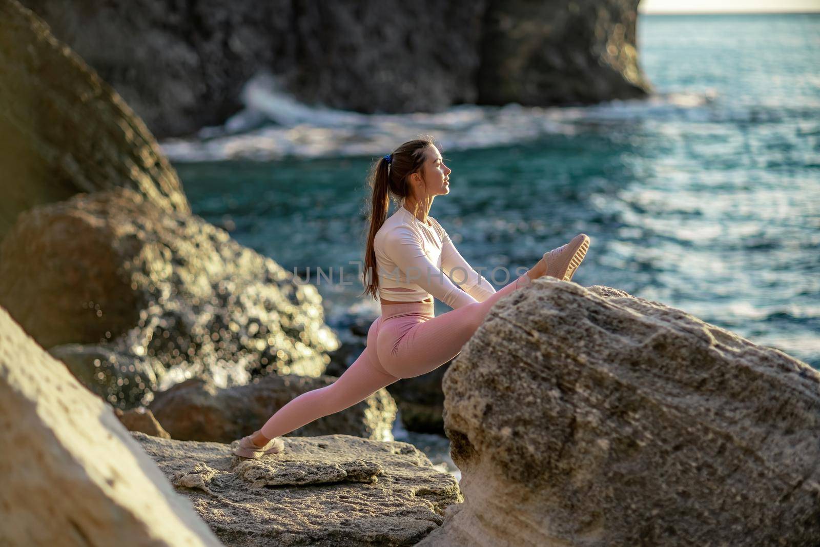 Girl gymnast is training on the beach by the sea. Does twine. Photo series.