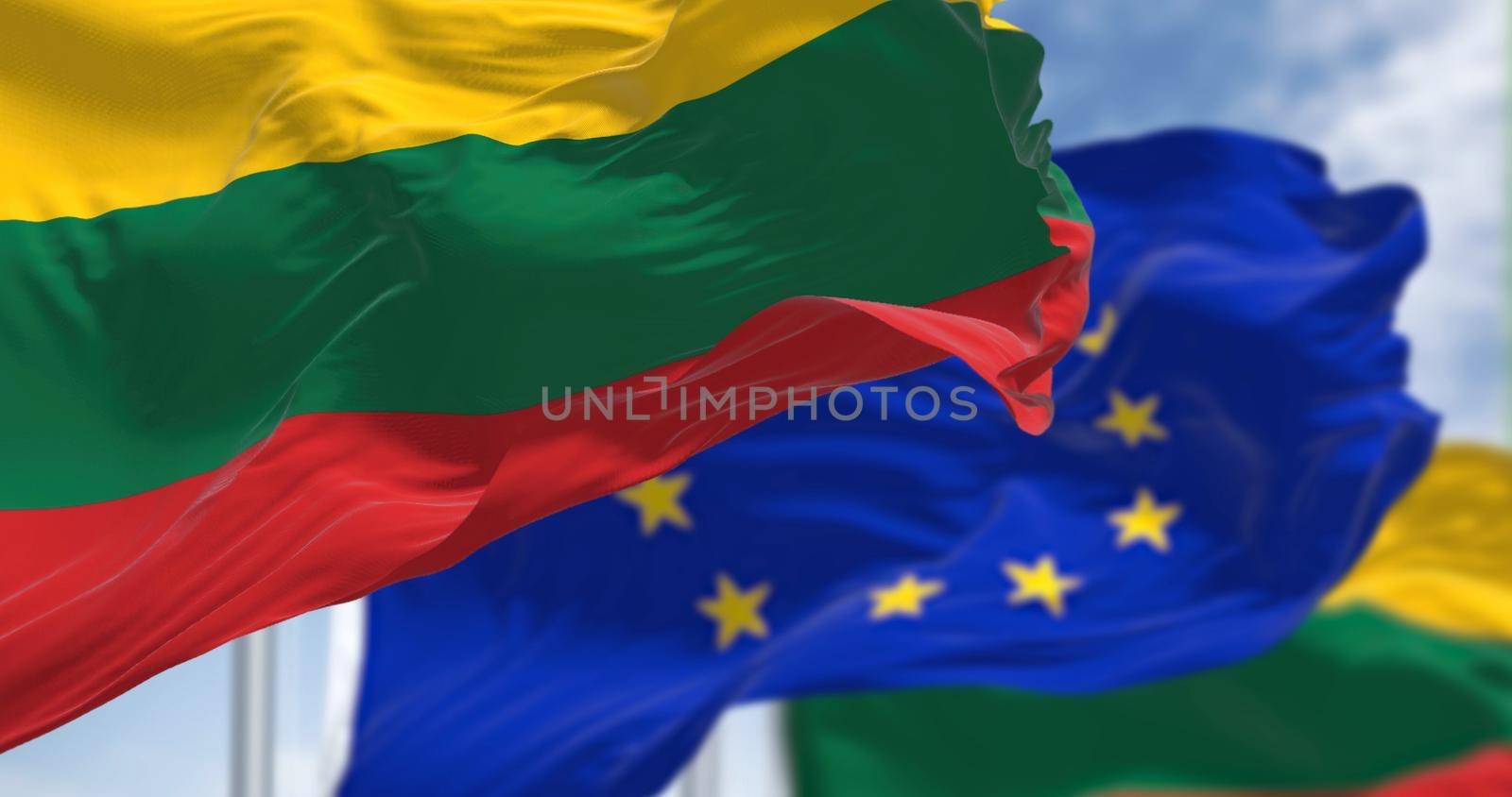 Detail of the national flag of Lithuania waving in the wind with blurred european union flag in the background by rarrarorro