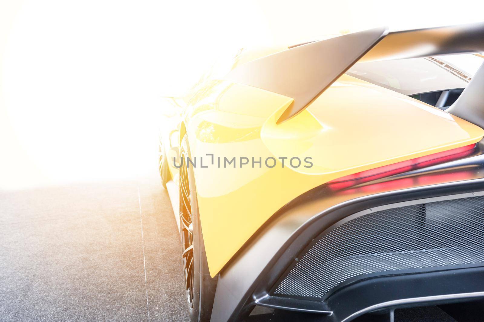 Back of a yellow sport car in sunset background