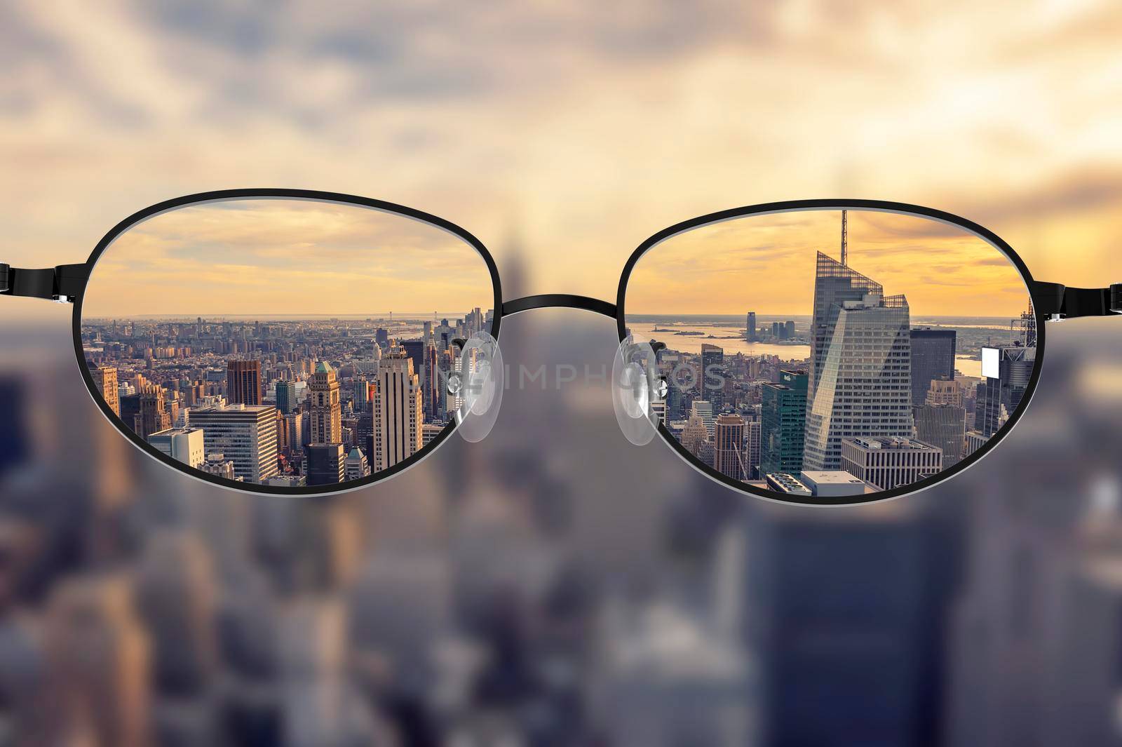 Clear cityscape focused in glasses lenses with blurred cityscape background
