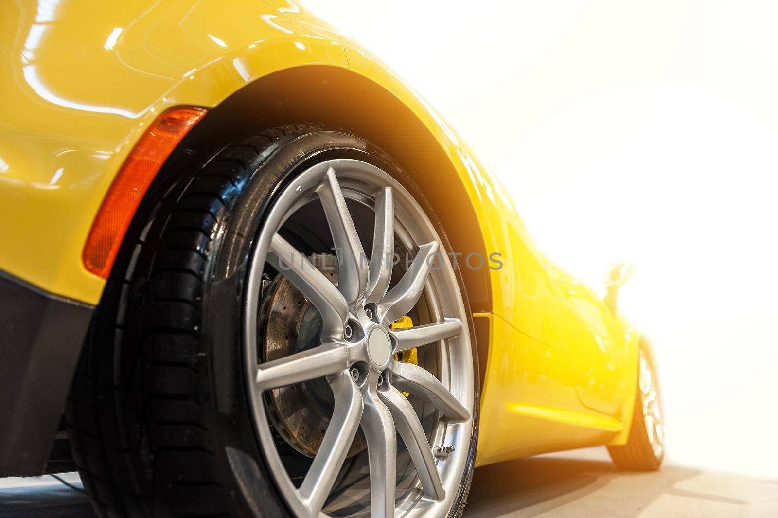 Back of a generic yellow sport car isolated in the sunlight