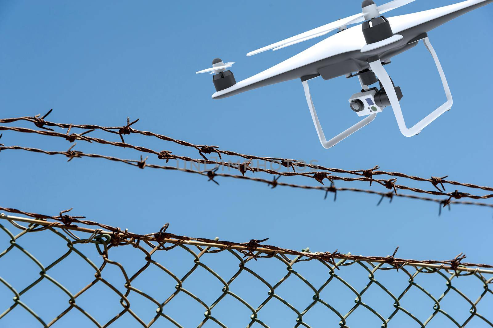 Drone with digital camera flying over a barbed wire fence by cla78
