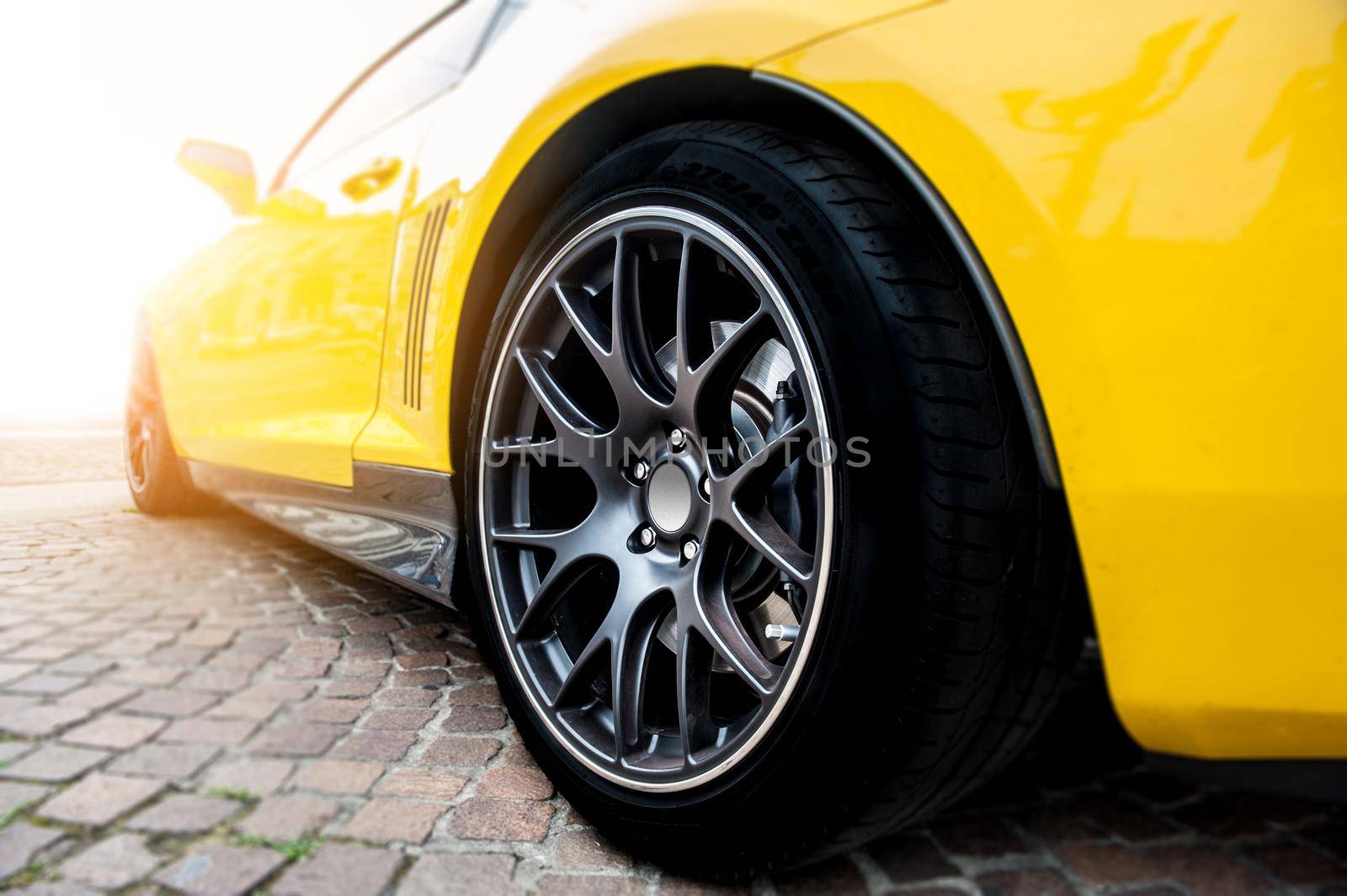 Back of a yellow modern sport car in sunset