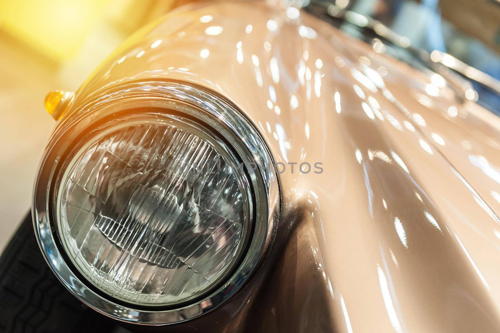 Closeup on headlight of a vintage car in the sunlight