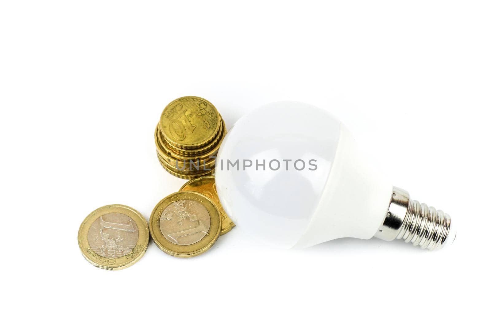 Led light bulb next to euro coins on white background