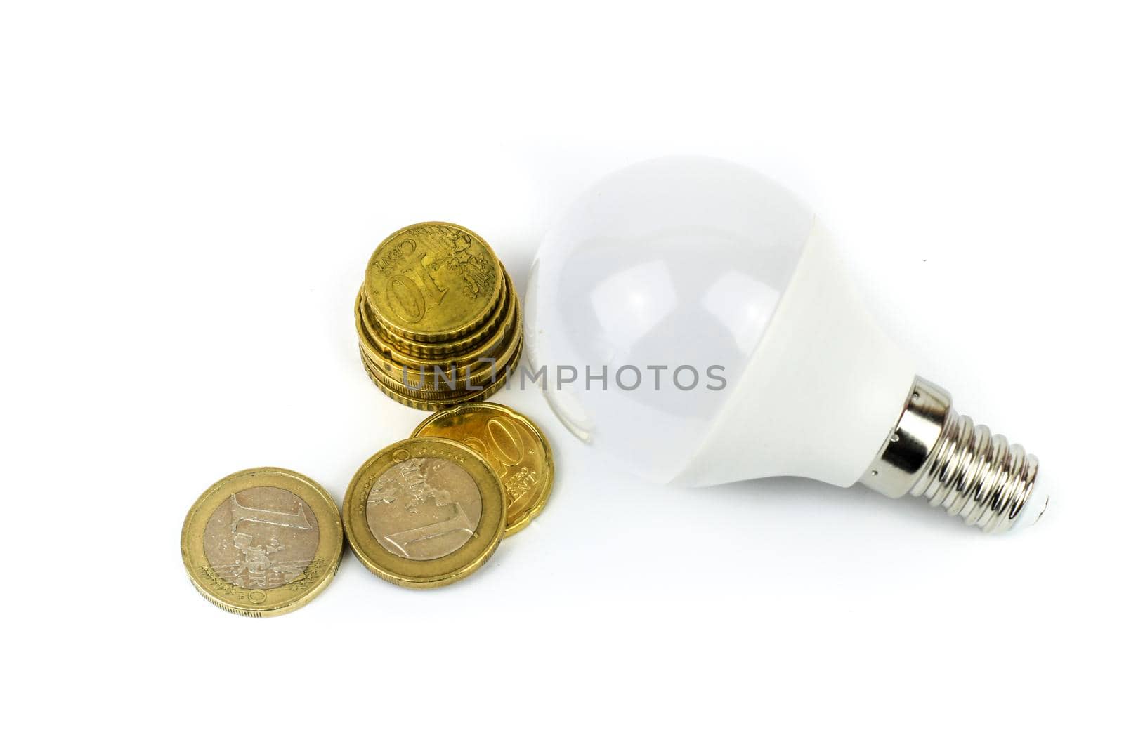 Led light bulb next to euro coins on white background