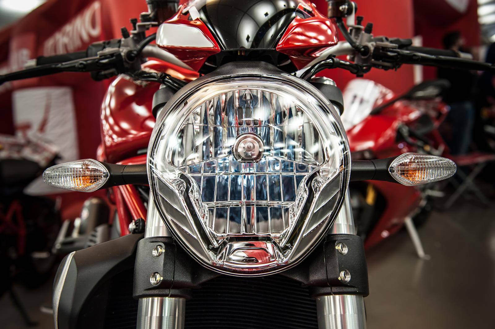 Headlight of a modern motorcycle in a salon