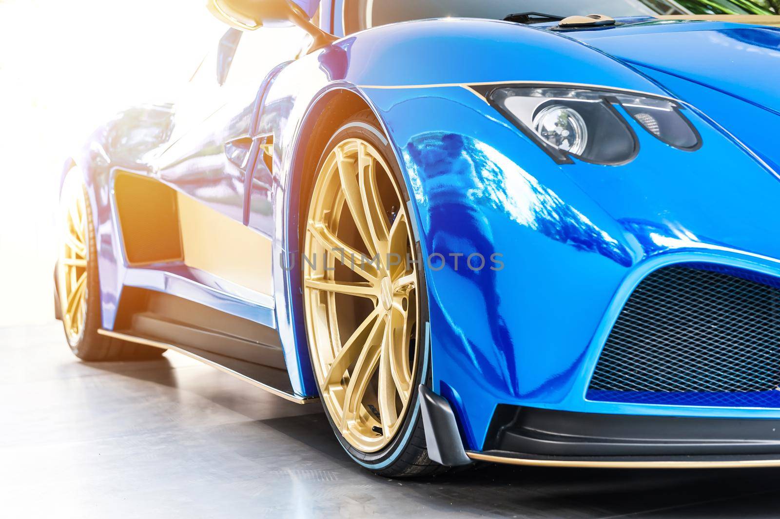 Font of a blue sport luxury car in sunset background