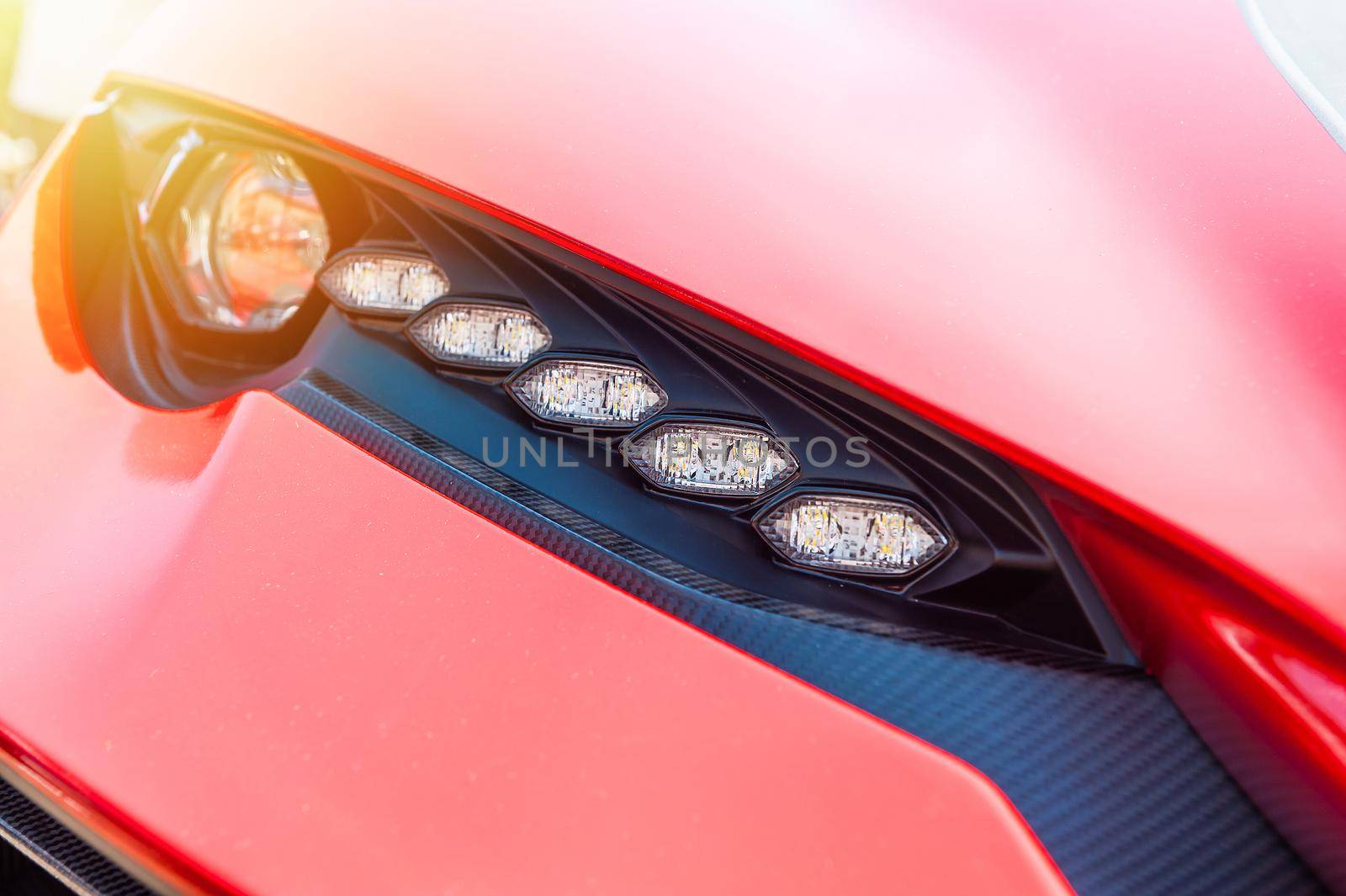 Close up of a red sport luxury car in sunset background