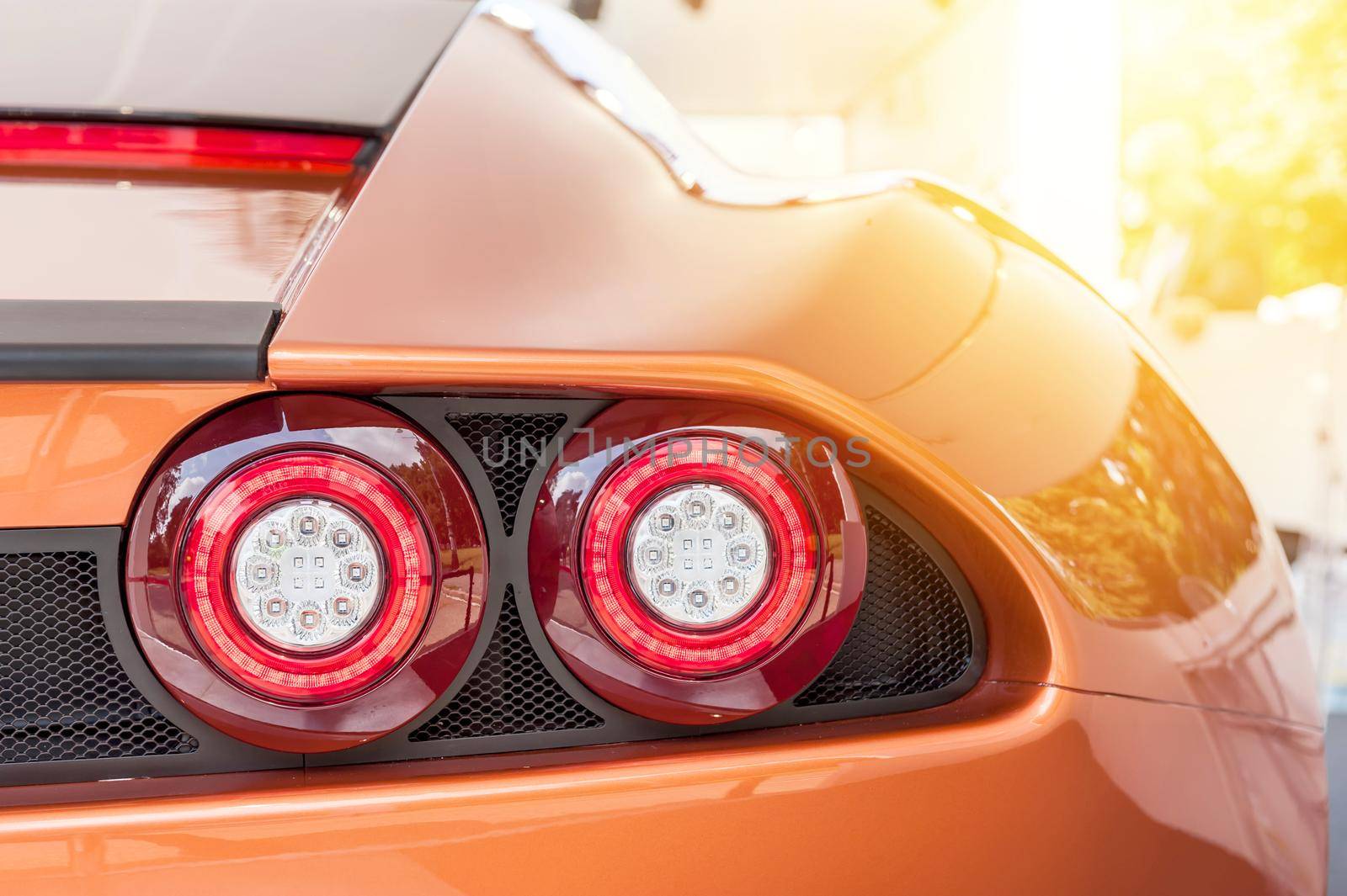 Back of an orange sport luxury car in sunset by cla78
