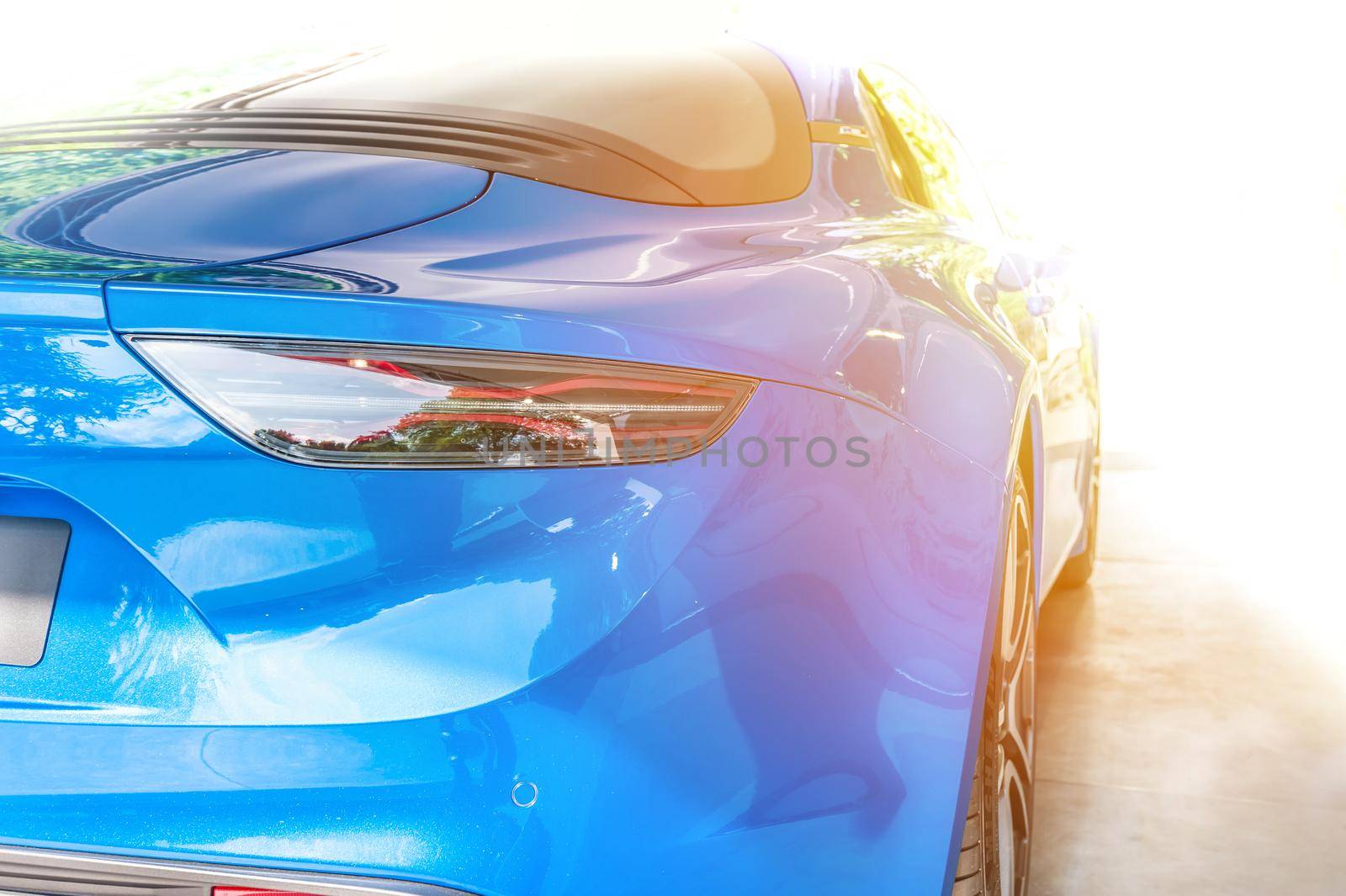 Back of a blue sport car in sunset background