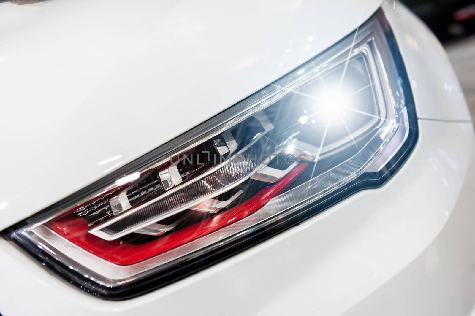 Closeup on an headlight of a sport car by cla78