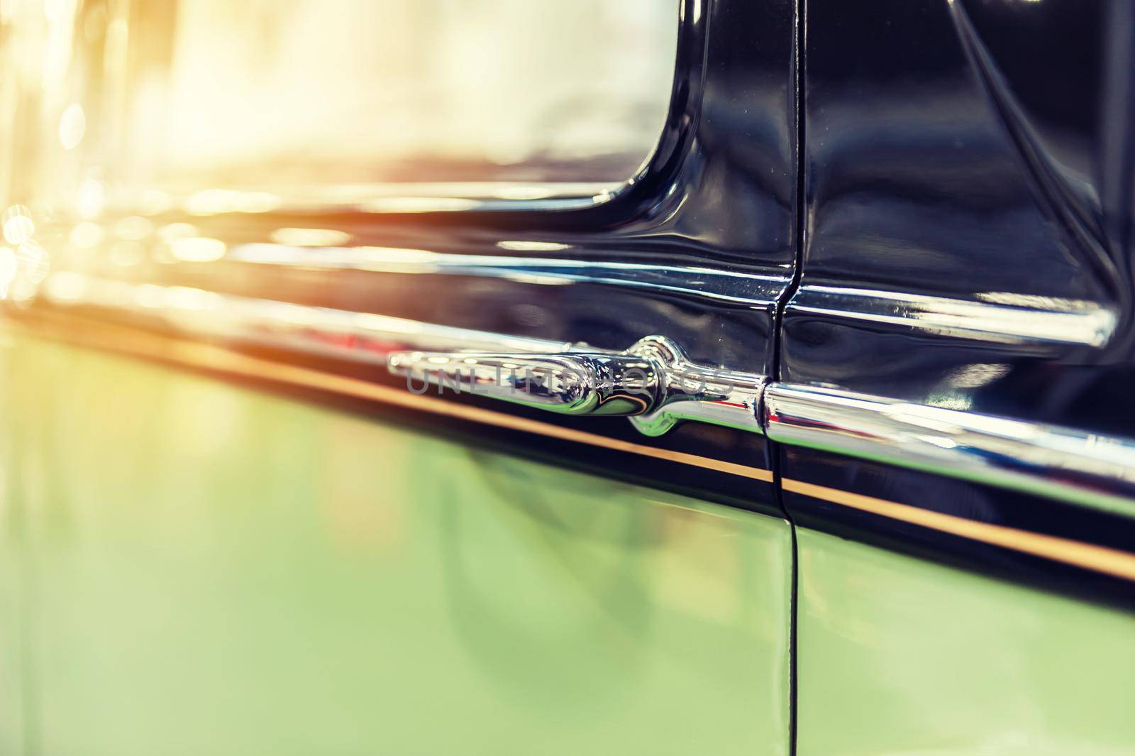 Closeup of a green vintage car in sunlight