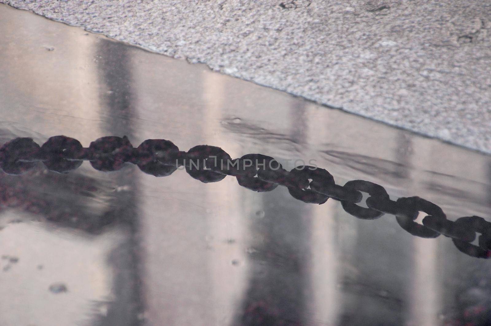 Black chain links reflection closeup before embankment by Proff